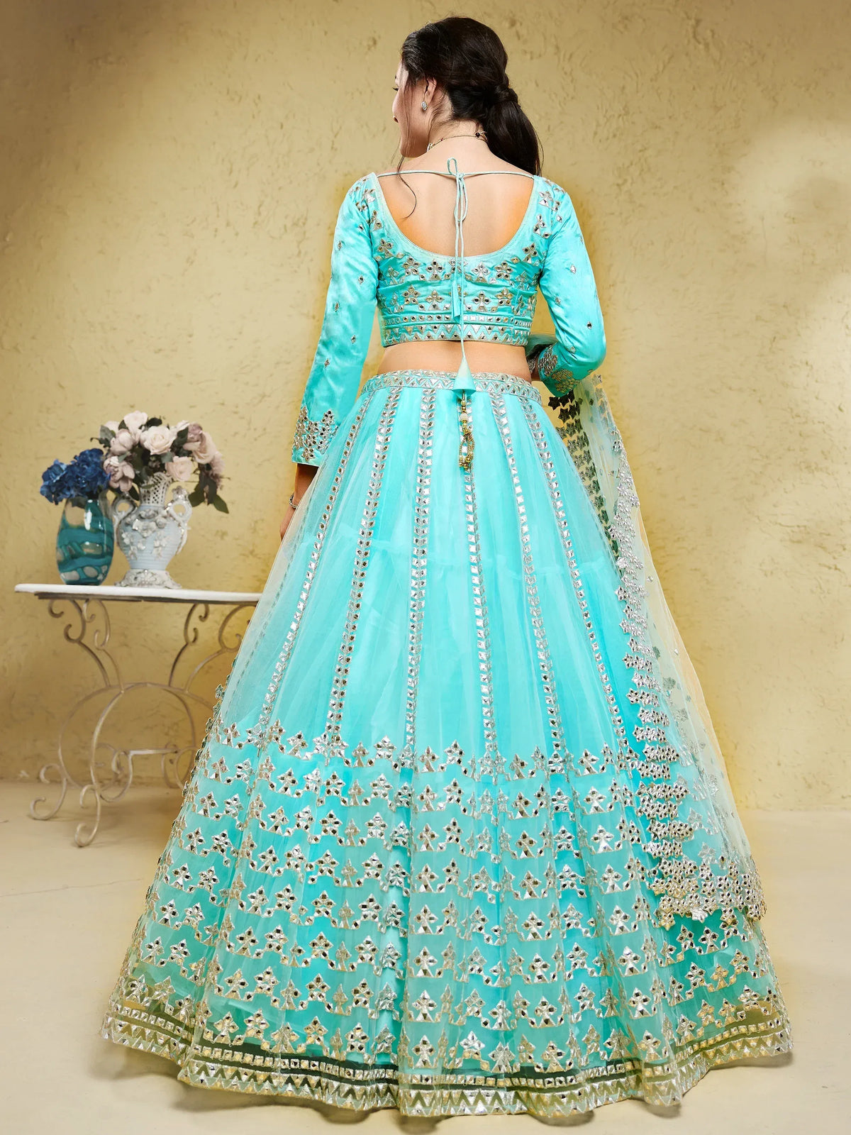 Turquoise designer lehenga choli with mirror work and open back blouse, perfect for Indian ethnic wear.