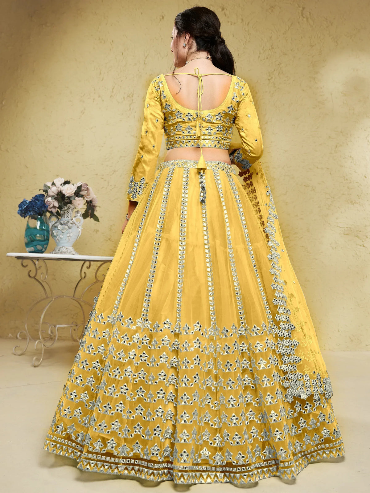 Yellow designer lehenga choli with silver mirror work and back tie detail