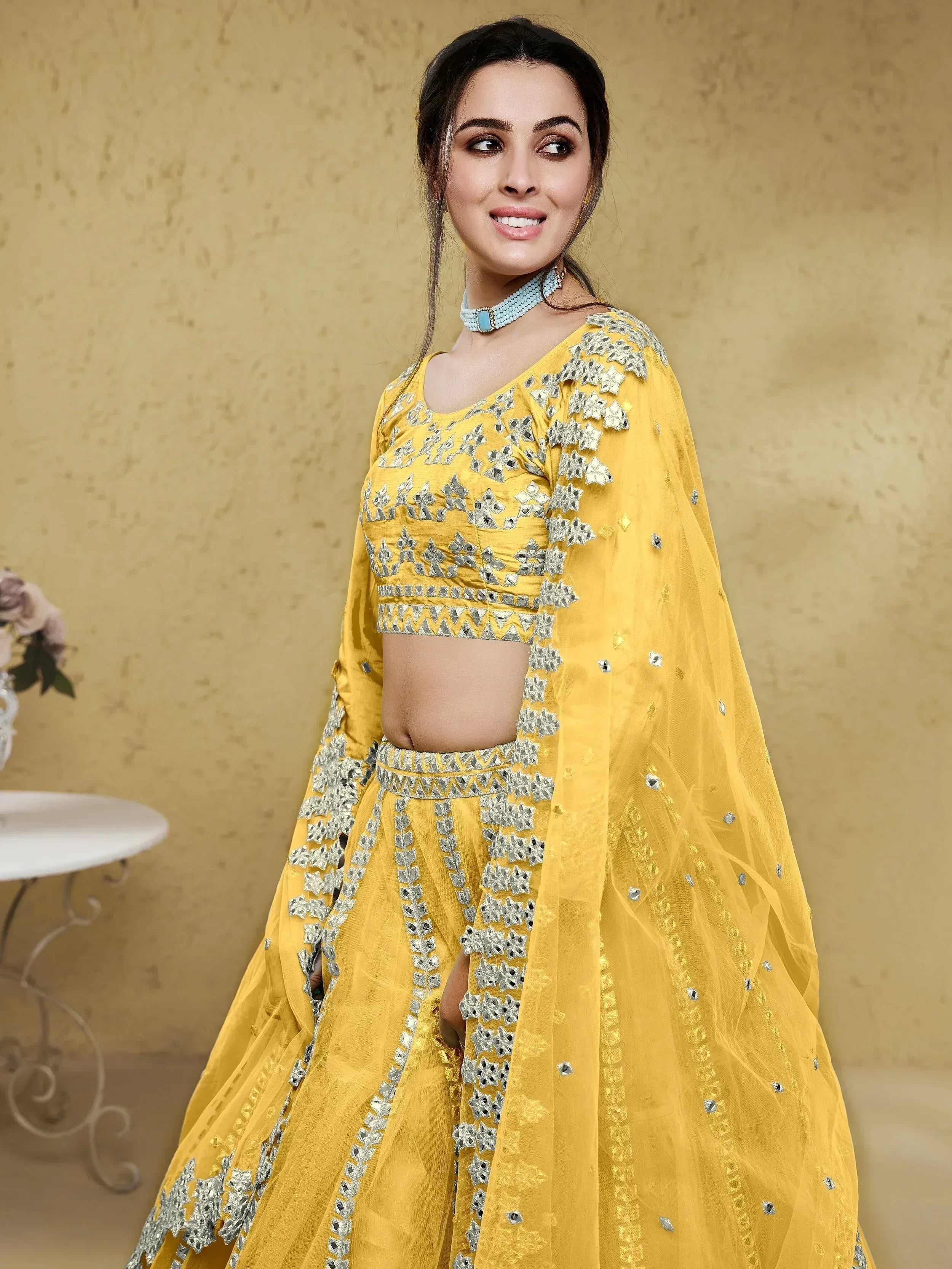 Yellow designer lehenga choli with silver mirror work and floral embroidery, perfect for Indian ethnic wear.