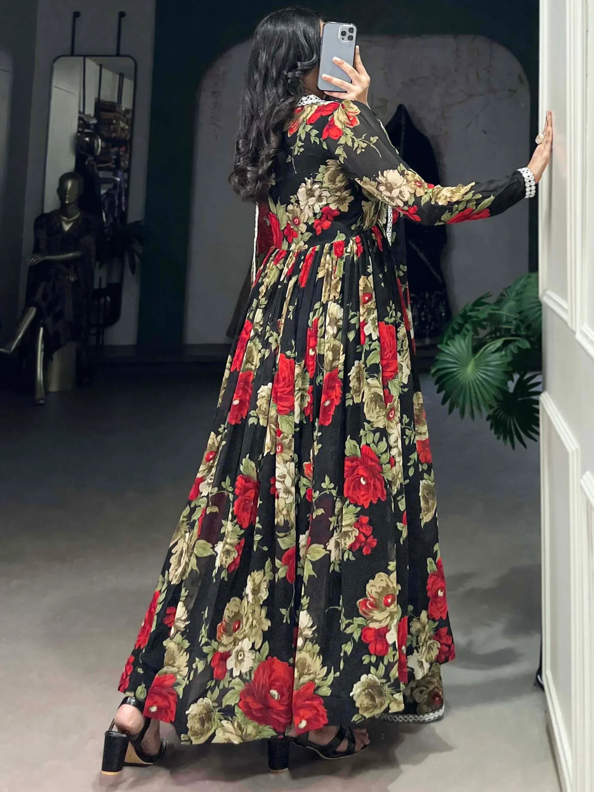 Black floral ethnic gown with red and cream roses, long sleeves, pleated skirt, perfect for Indian occasions