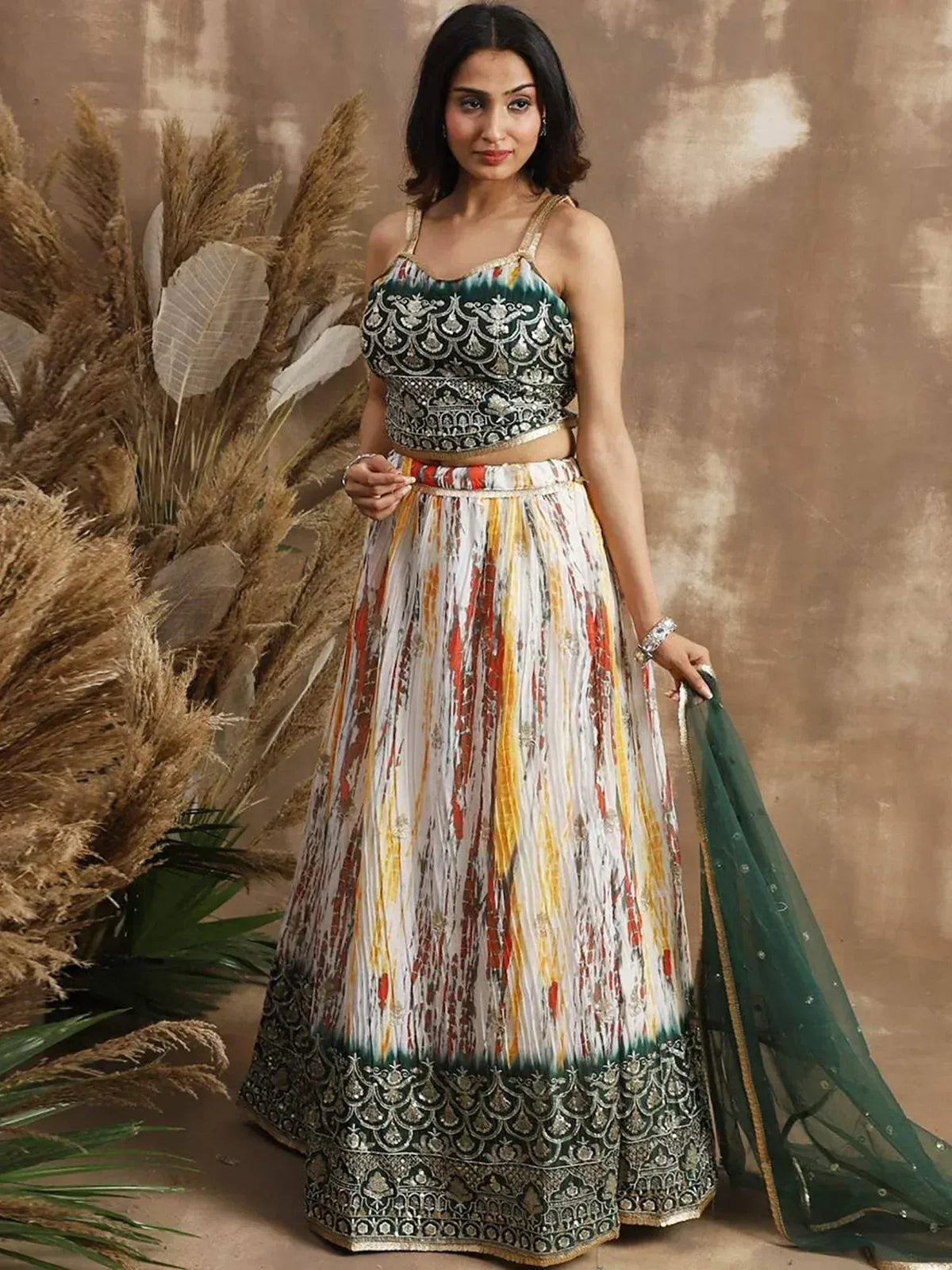 Woman in designer lehenga choli with embroidered top, printed skirt, and green dupatta, perfect for Indian ethnic wear occasions.