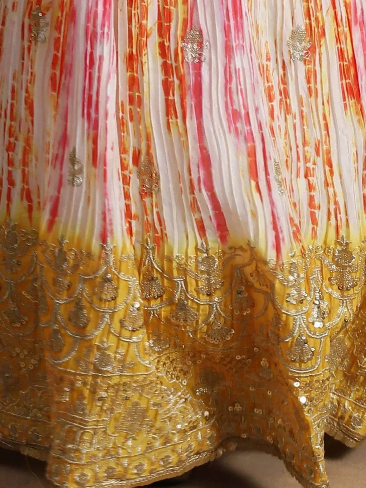 Vibrant tie-dye lehenga with gold embroidery and sequin detailing, perfect for Indian ethnic wear occasions.