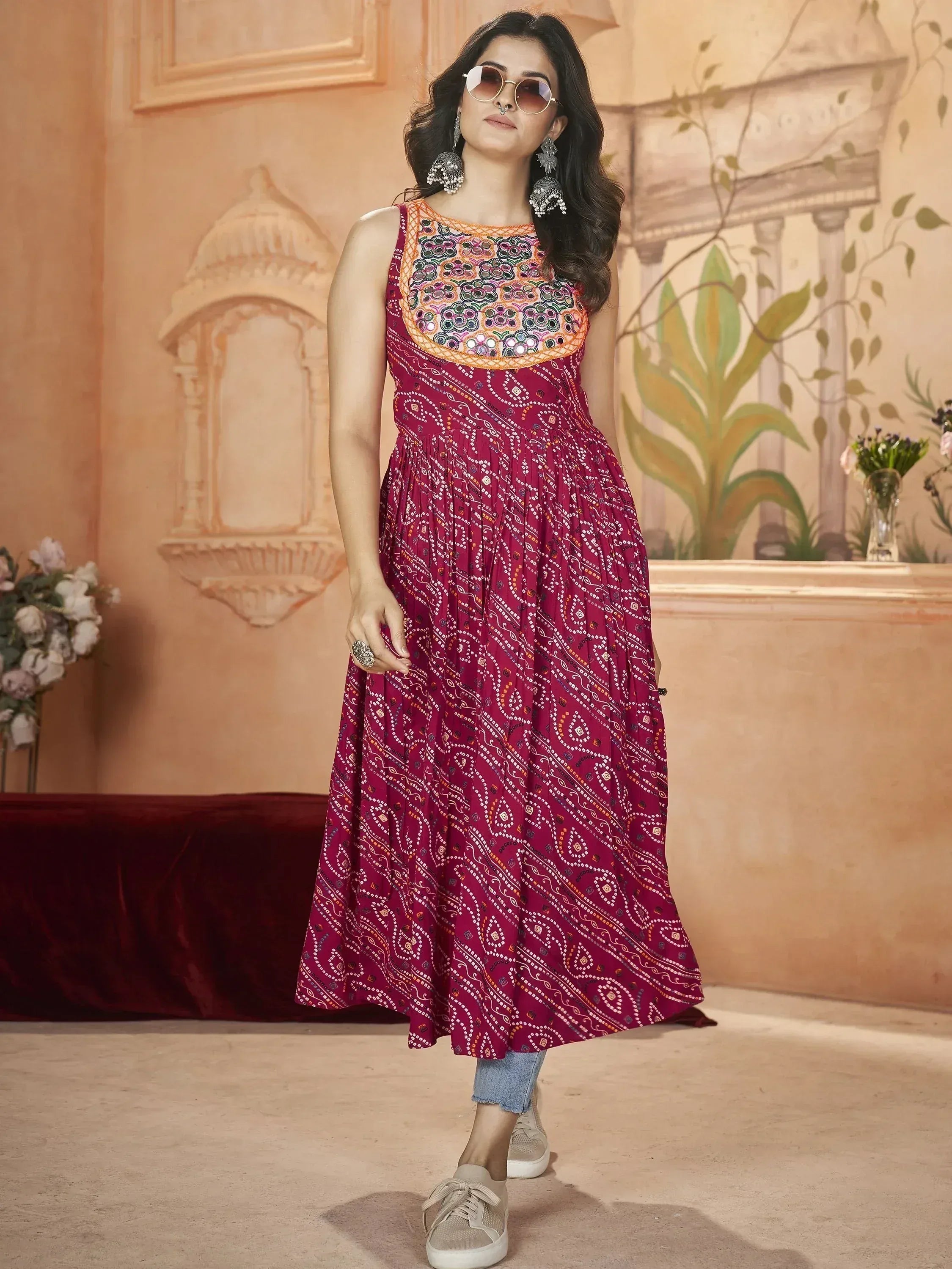 Maroon ethnic gown with mirror work and printed skirt, styled with jeans and sneakers for casual wear