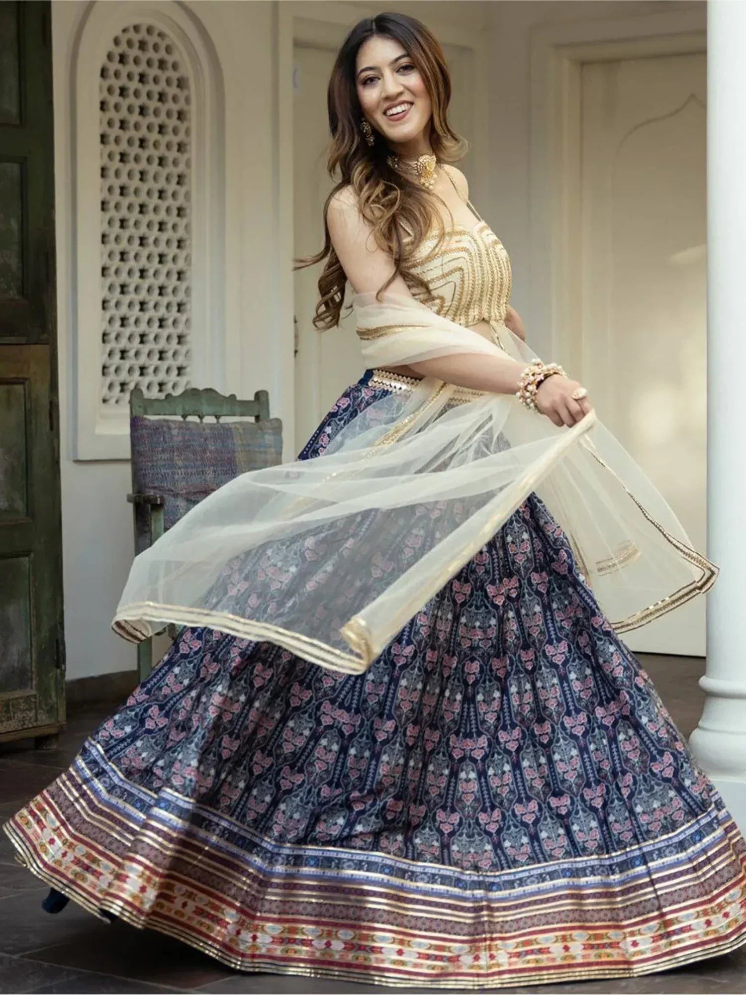 Woman in elegant Indian lehenga choli with floral print skirt and gold embroidery, perfect for weddings or festivals