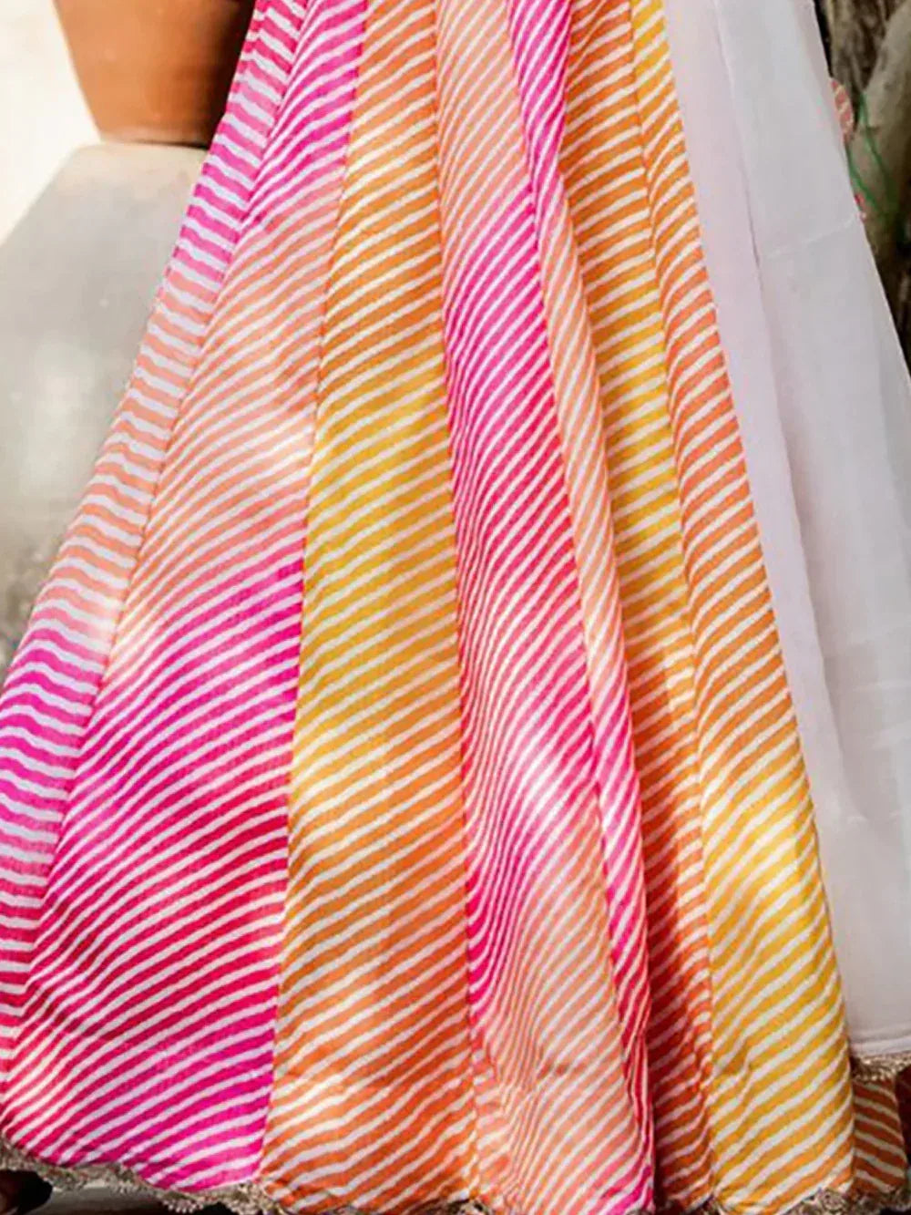 Vibrant striped lehenga choli in pink, orange, and yellow hues for festive Indian ethnic wear