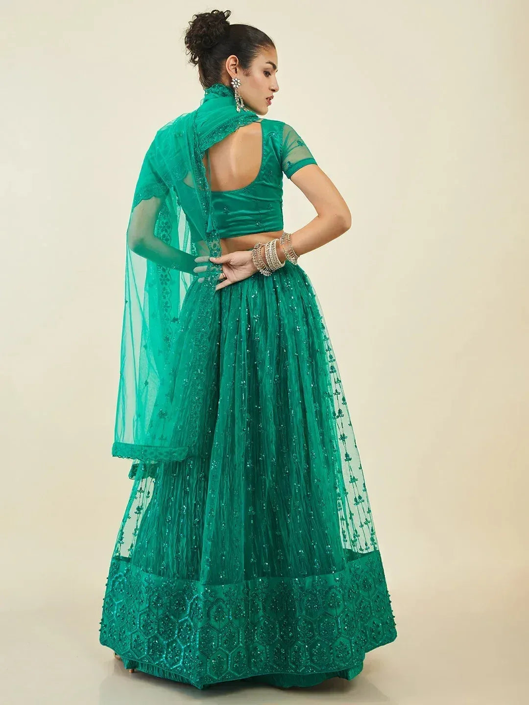 Emerald green designer lehenga choli with intricate embroidery and sheer dupatta