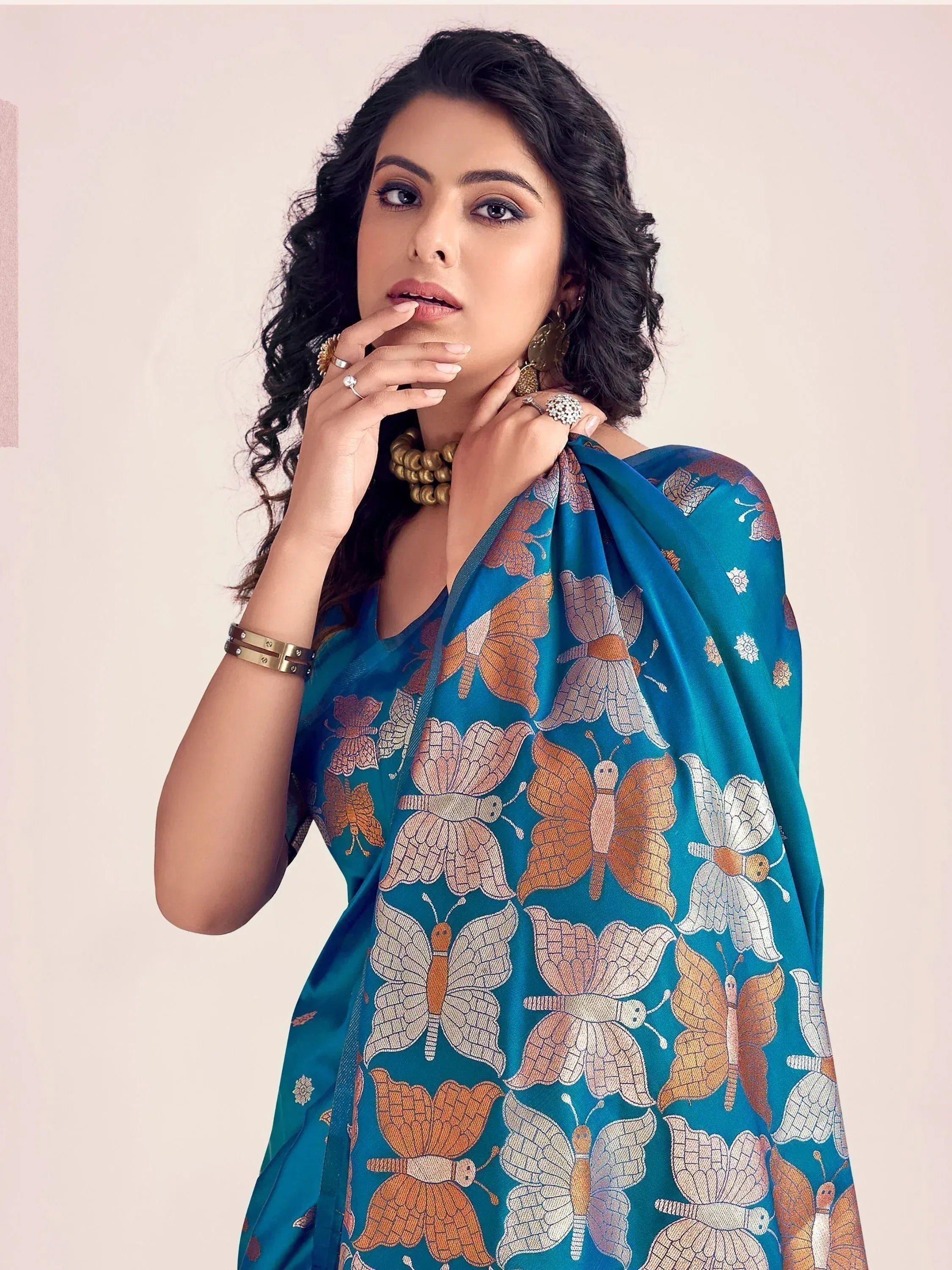 Teal ethnic gown with butterfly print, styled with gold jewelry for festive occasions