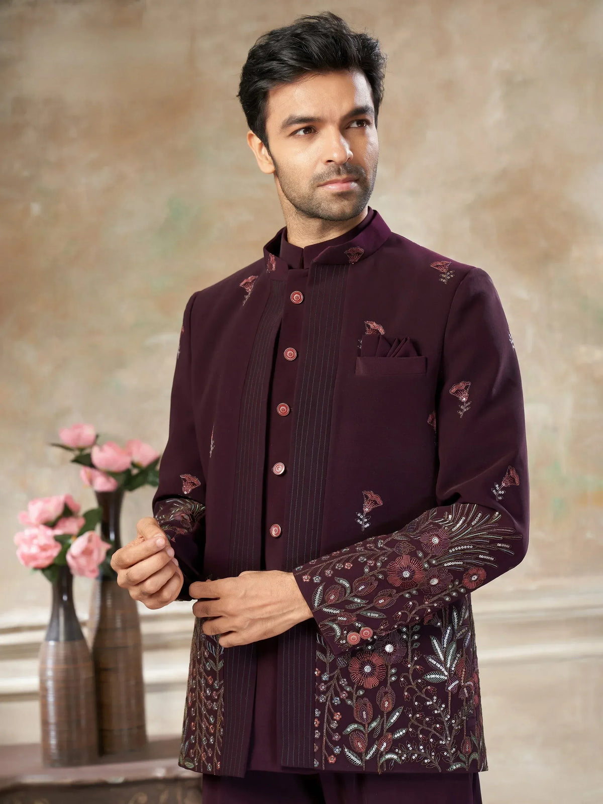 Man in maroon embroidered Indian sherwani with floral detailing, perfect for weddings and festive occasions