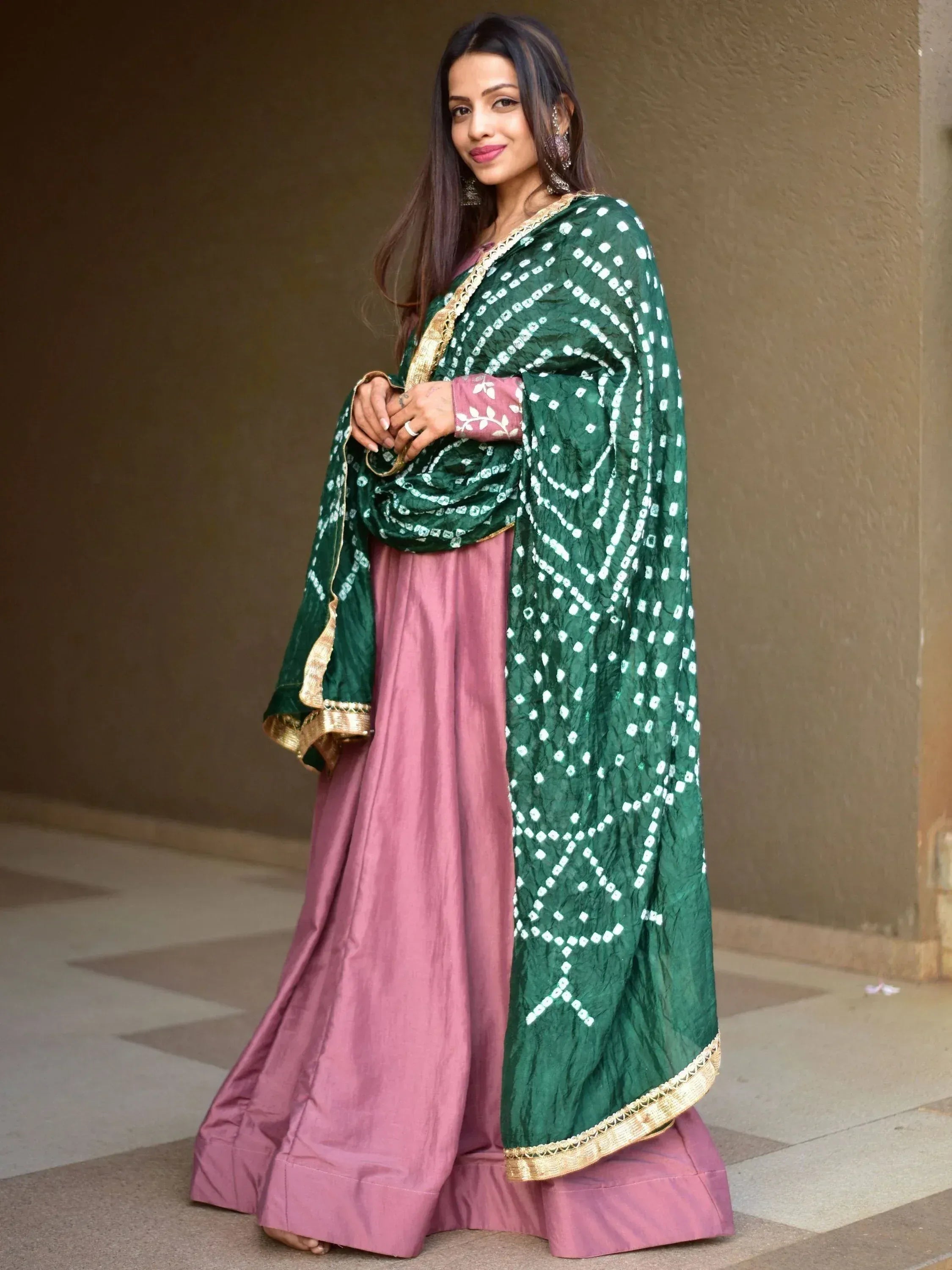 Woman in pink lehenga with green printed dupatta, ethnic Indian wear