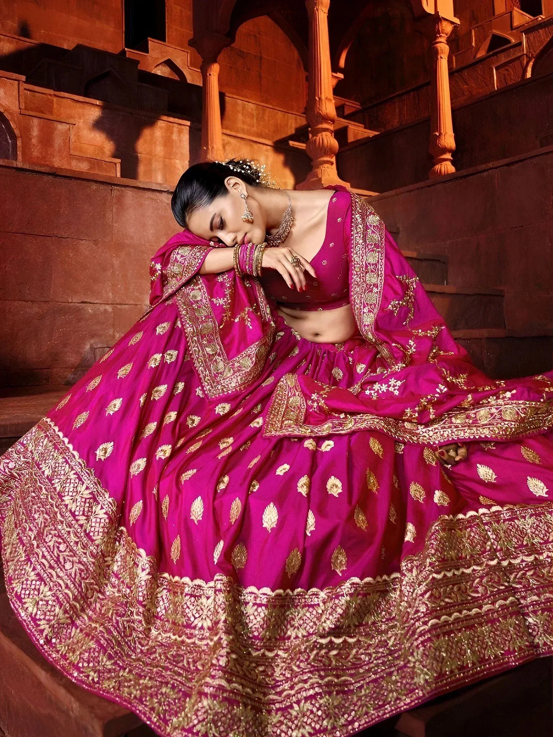 Magenta lehenga choli with gold embroidery, perfect for Indian weddings and festive occasions.