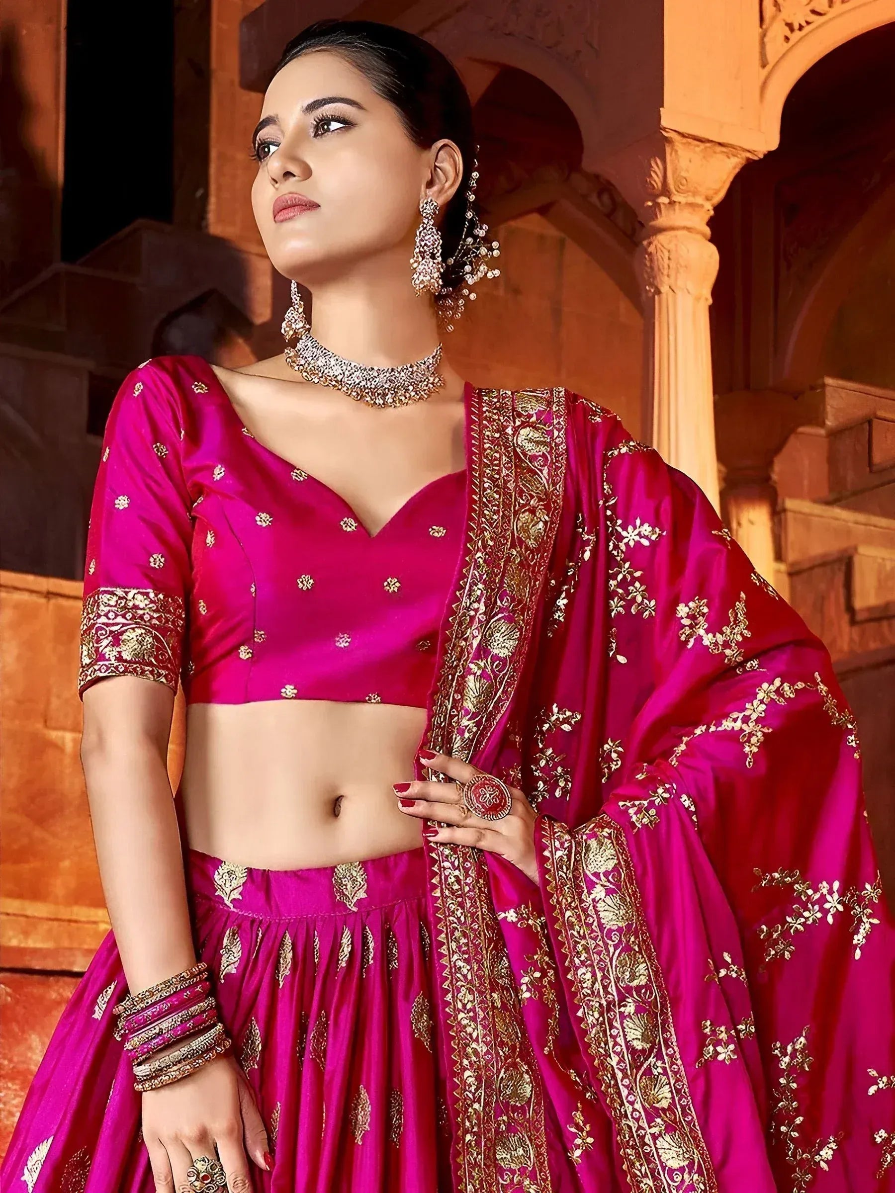Fuchsia designer lehenga choli with gold embroidery, perfect for Indian ethnic wear and festive occasions.