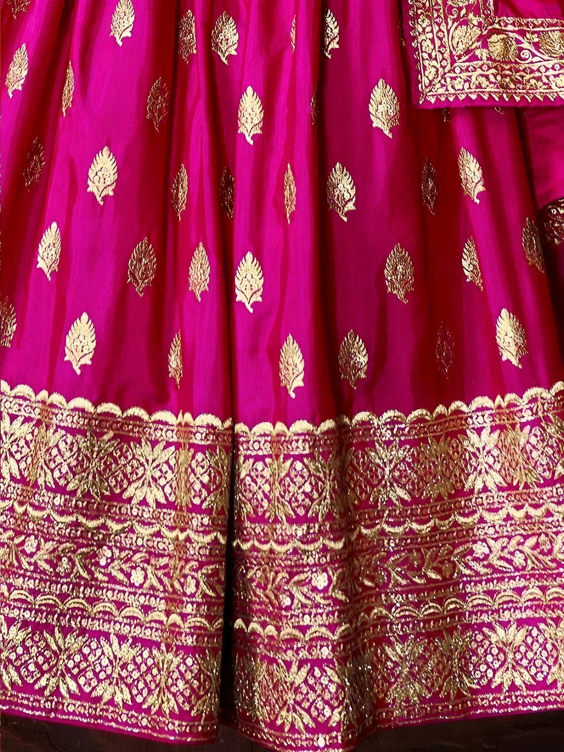 Fuchsia lehenga with gold leaf motifs and intricate border embroidery, perfect for Indian ethnic wear