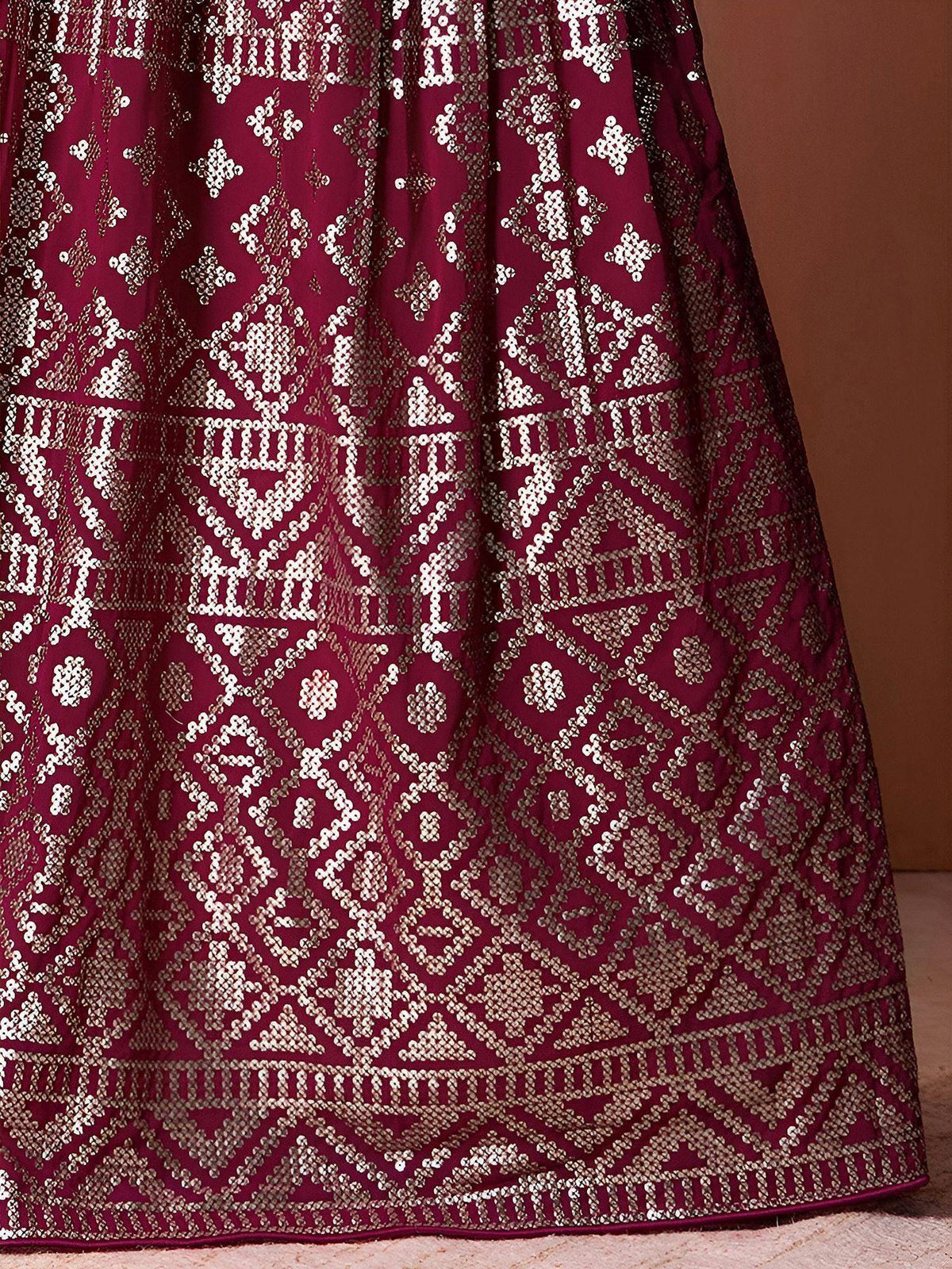 Maroon lehenga with intricate gold sequin embroidery, perfect for Indian ethnic wear and festive occasions.