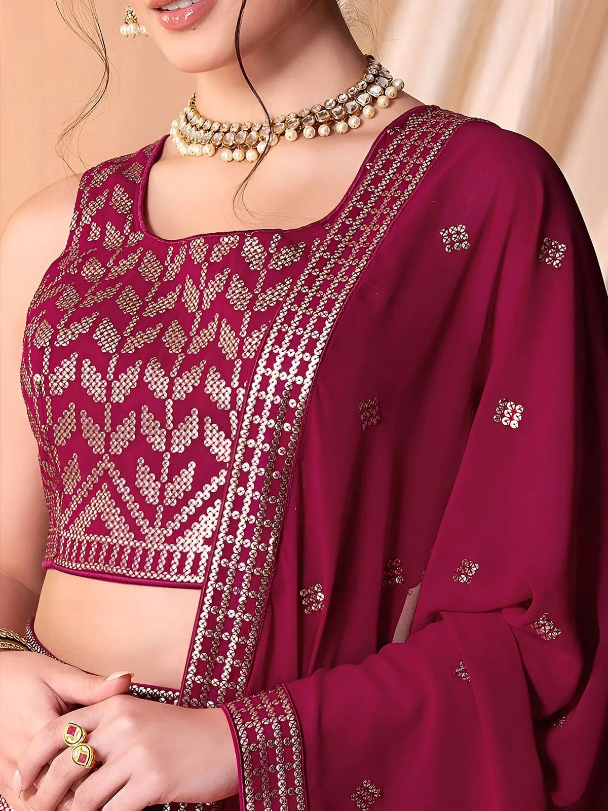 Maroon embroidered lehenga choli with gold mirror work and pearl jewelry