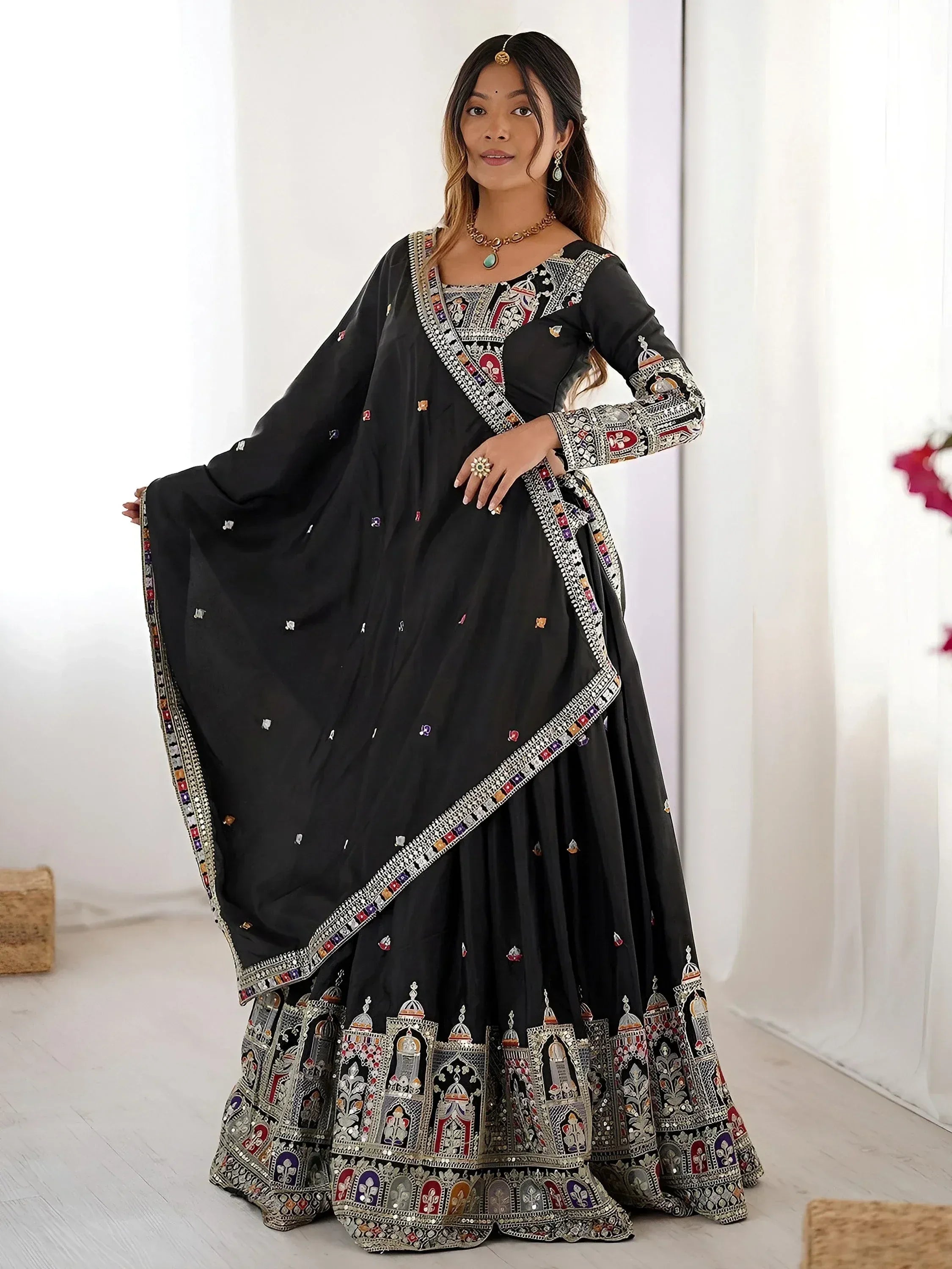 Black embroidered lehenga choli with intricate mirror work and colorful motifs, perfect for Indian ethnic wear.
