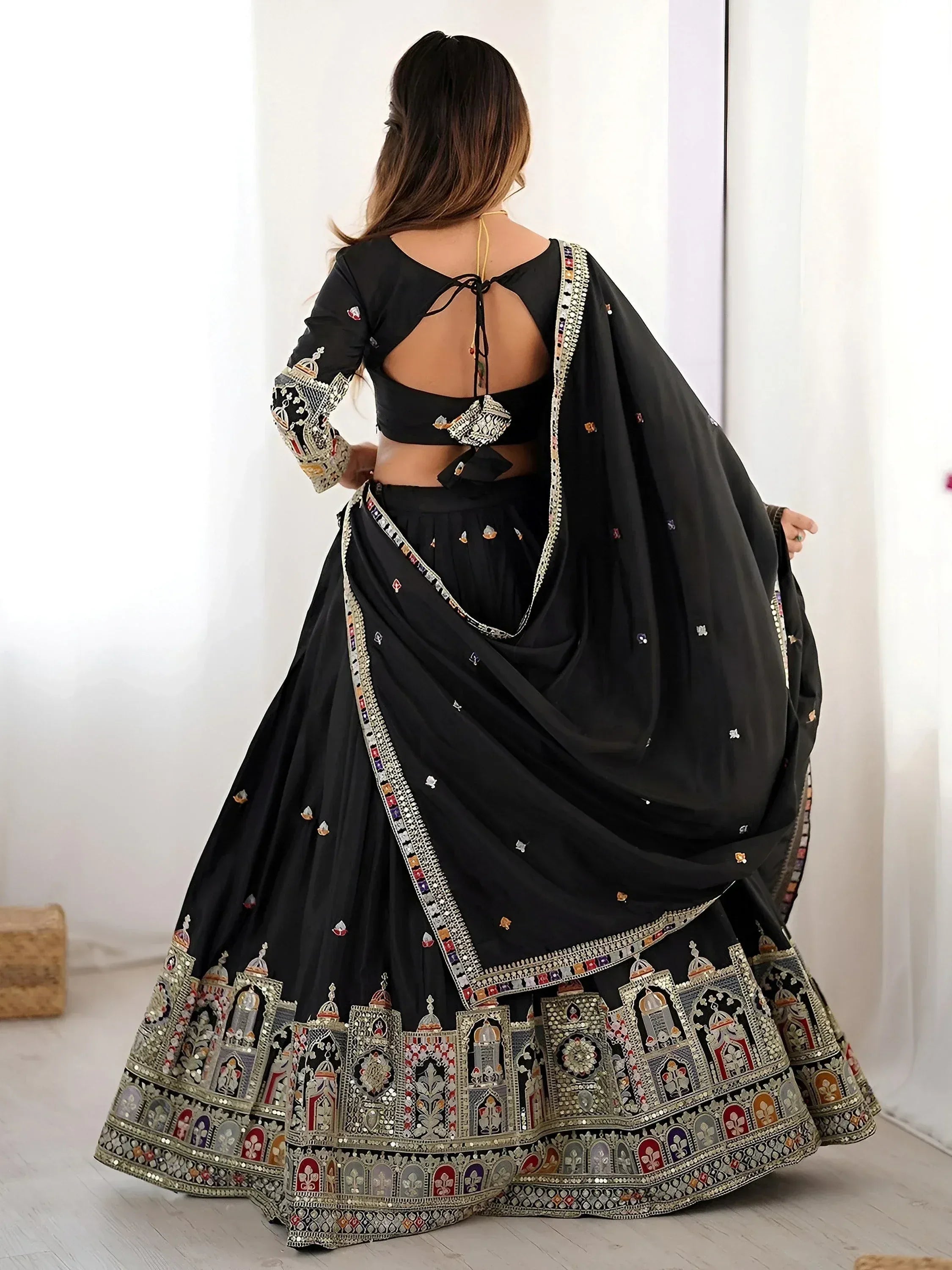 Black designer lehenga choli with intricate mirror work and embroidery, perfect for ethnic occasions.