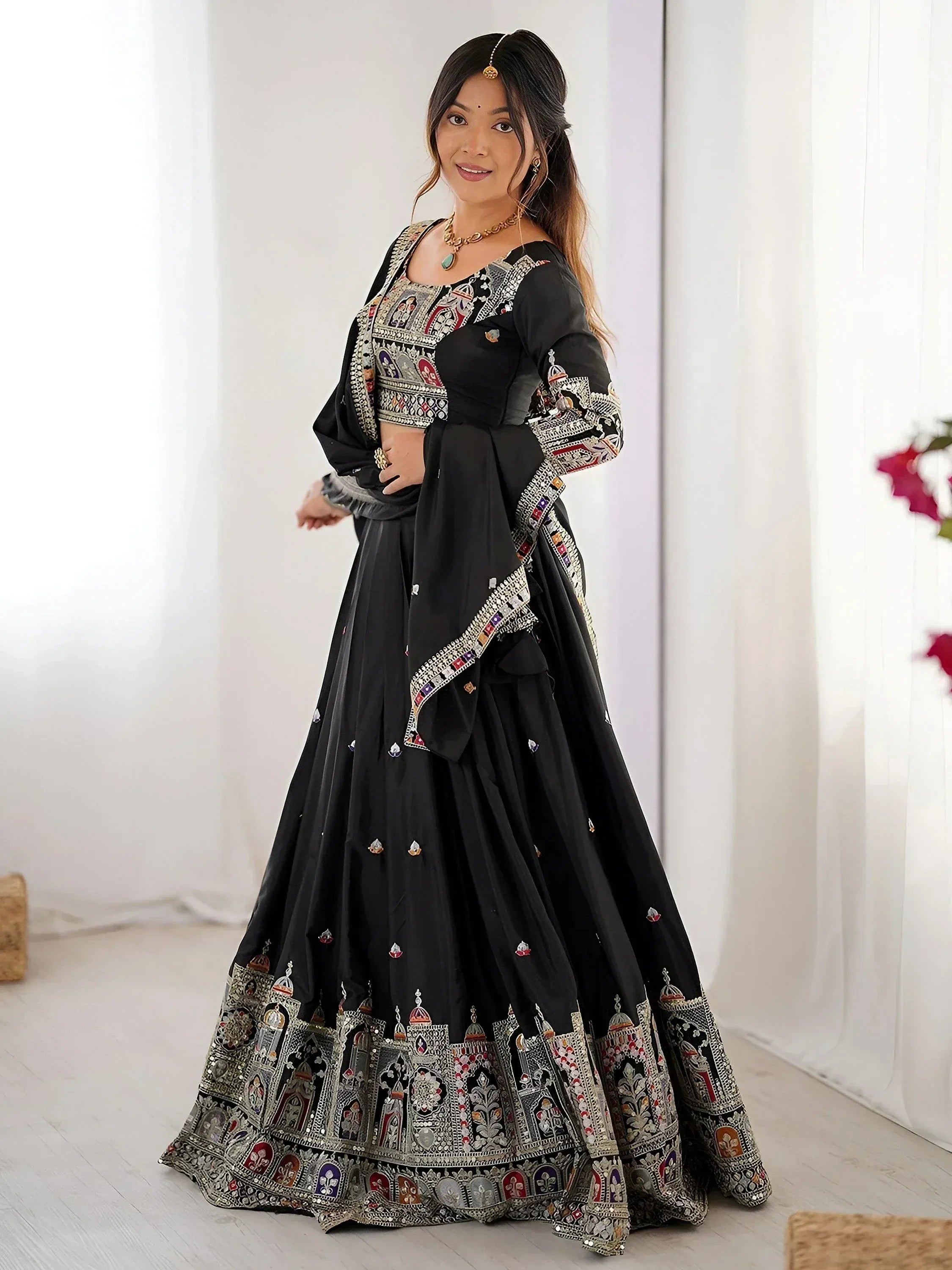 Black embroidered lehenga choli with intricate mirror work and colorful motifs, perfect for Indian ethnic wear.