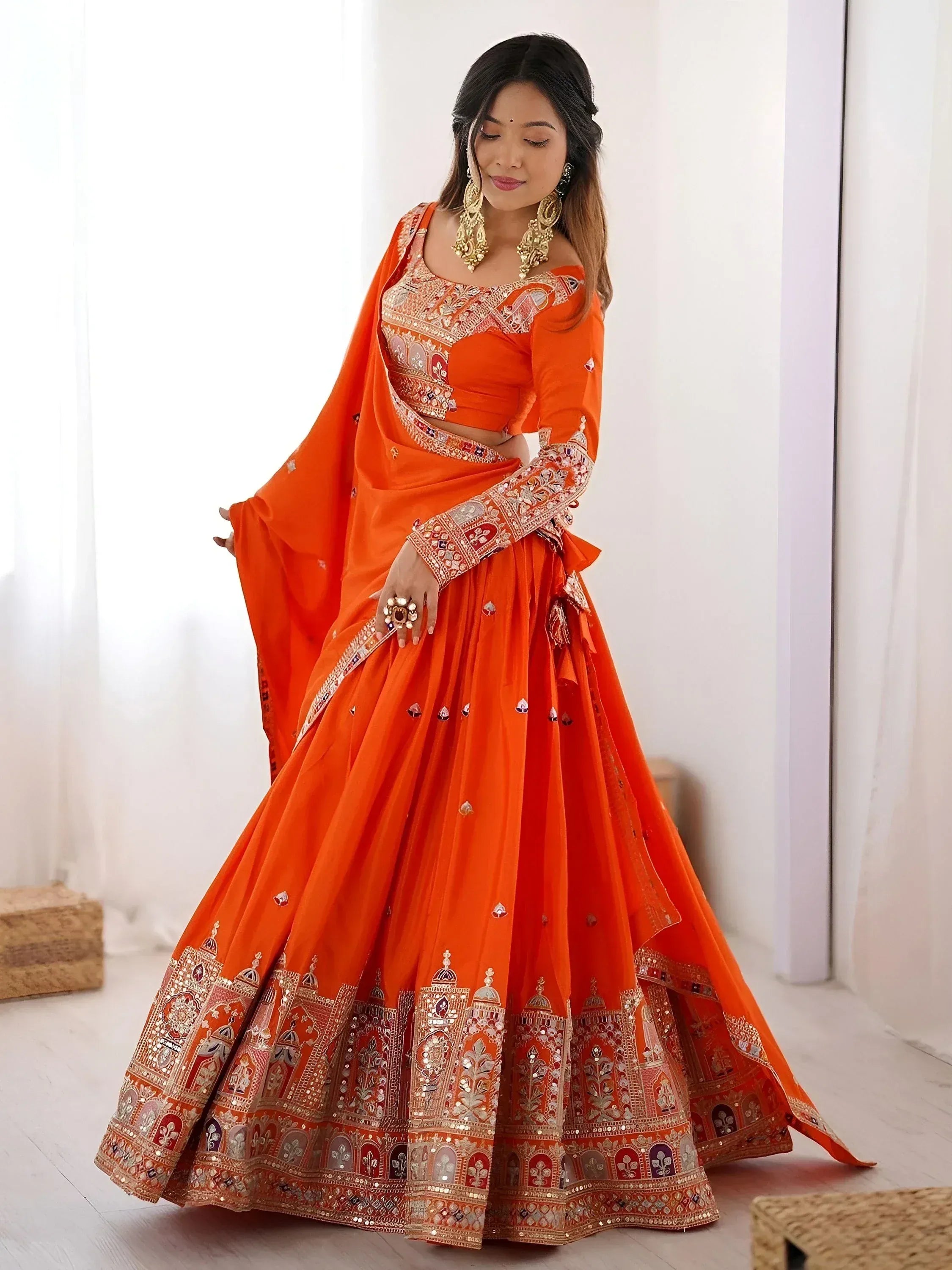 Orange embroidered lehenga choli with mirror work, perfect for Indian weddings and festive occasions