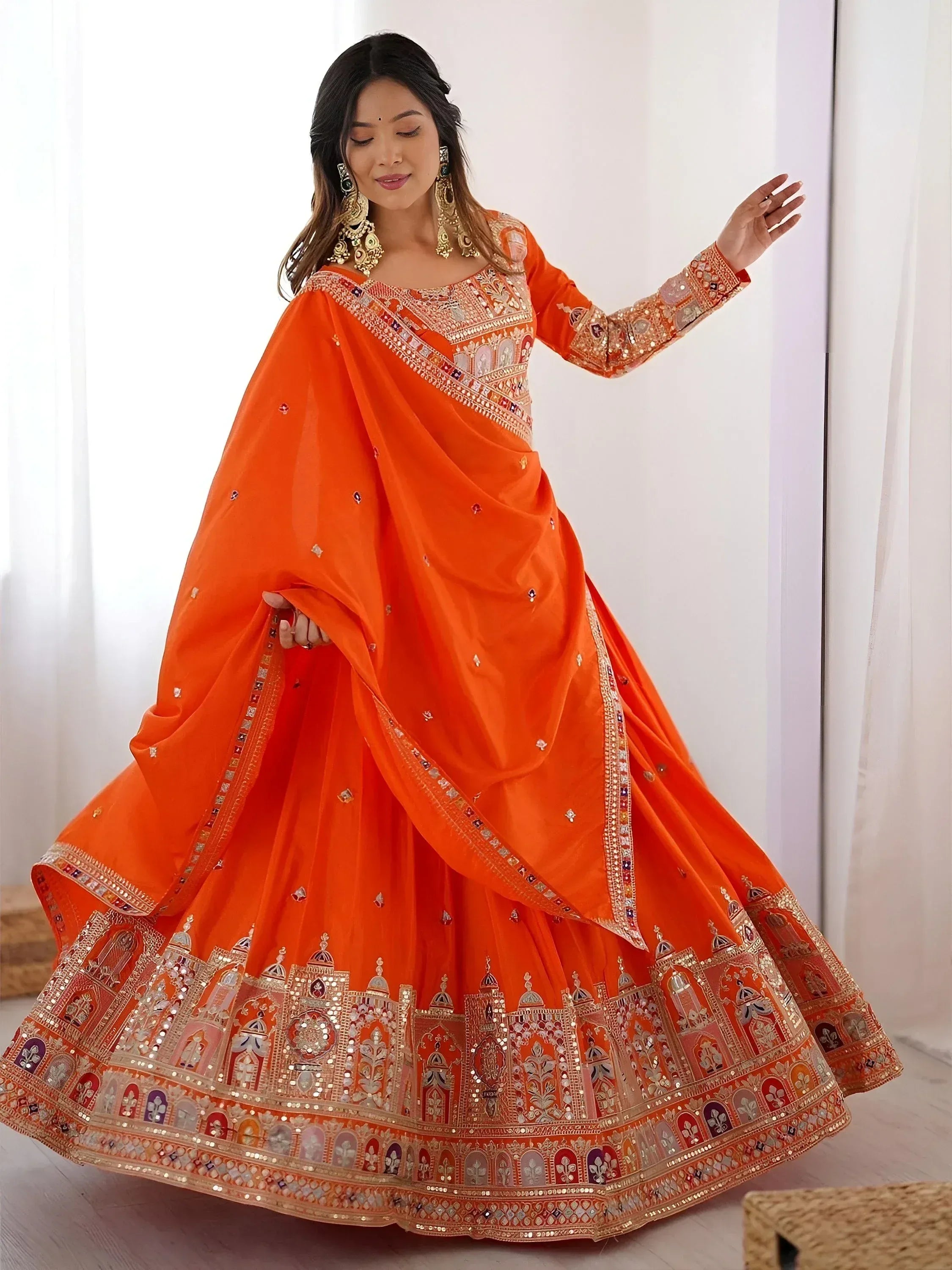 Orange designer lehenga choli with intricate mirror work and embroidery for Indian ethnic wear