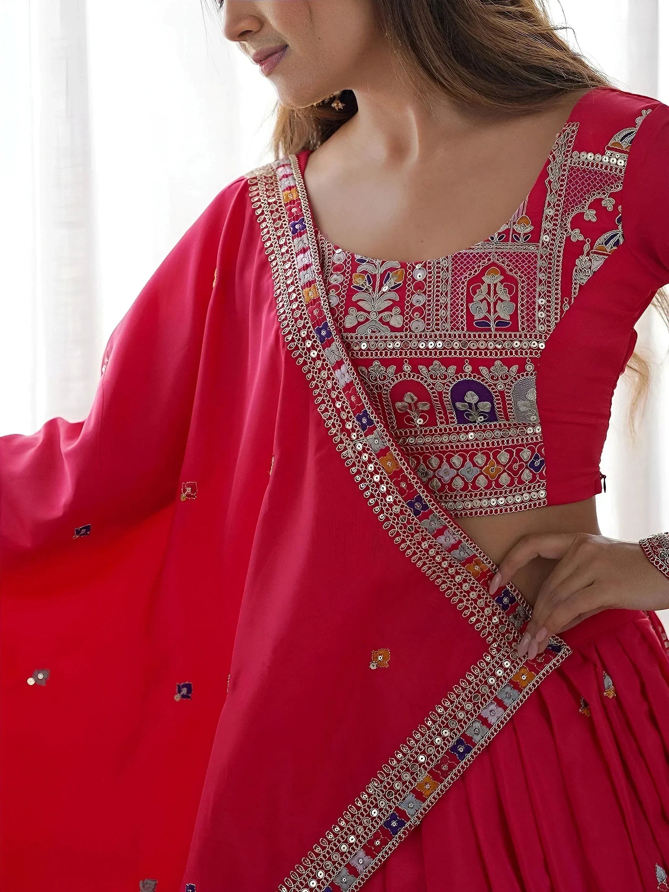 Red embroidered lehenga choli with mirror work and floral motifs, perfect for Indian ethnic wear