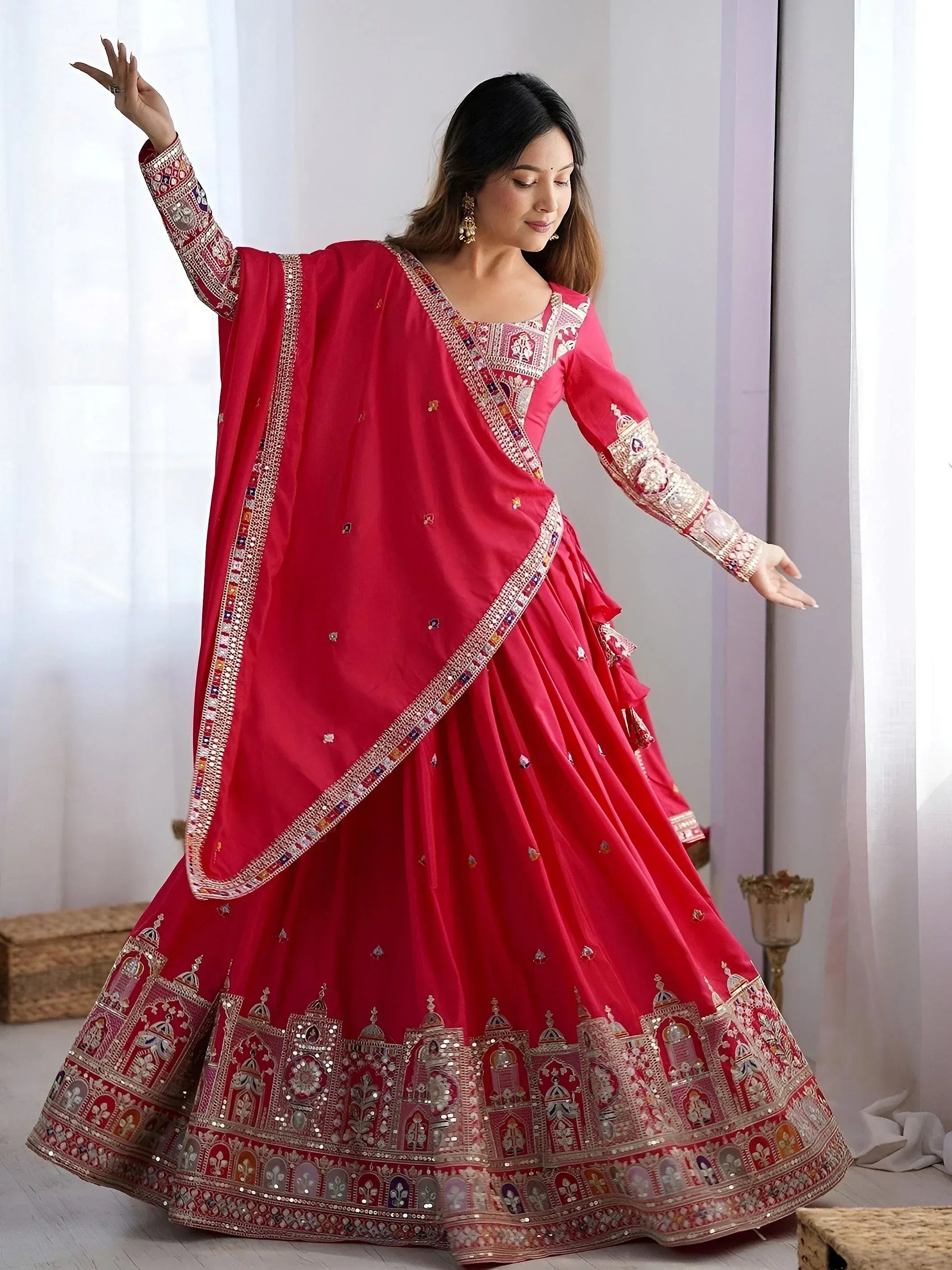 Red designer lehenga choli with heavy embroidery and mirror work, perfect for Indian weddings and festive occasions.