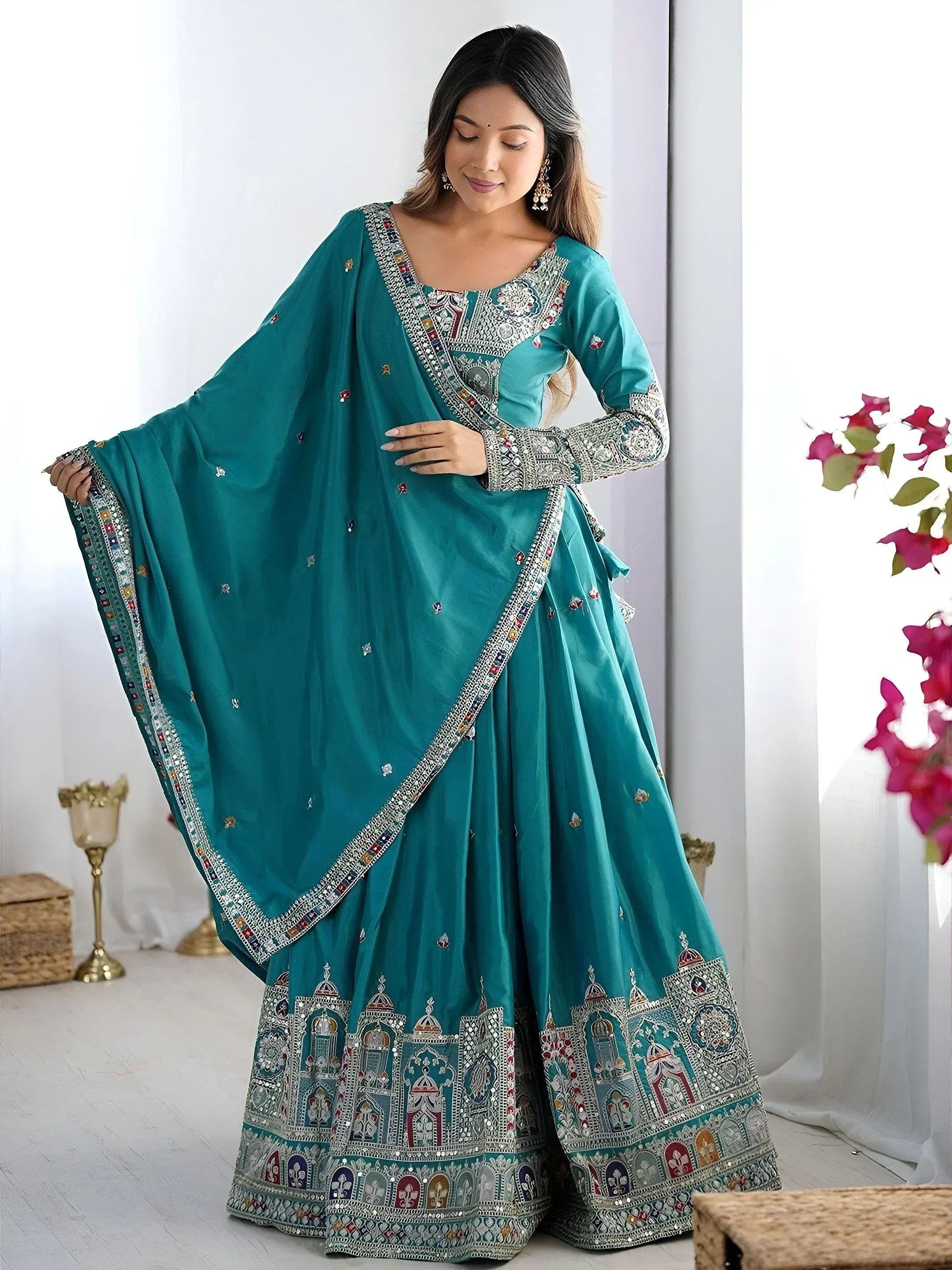 Teal designer lehenga choli with intricate embroidery and mirror work, perfect for Indian ethnic wear occasions.