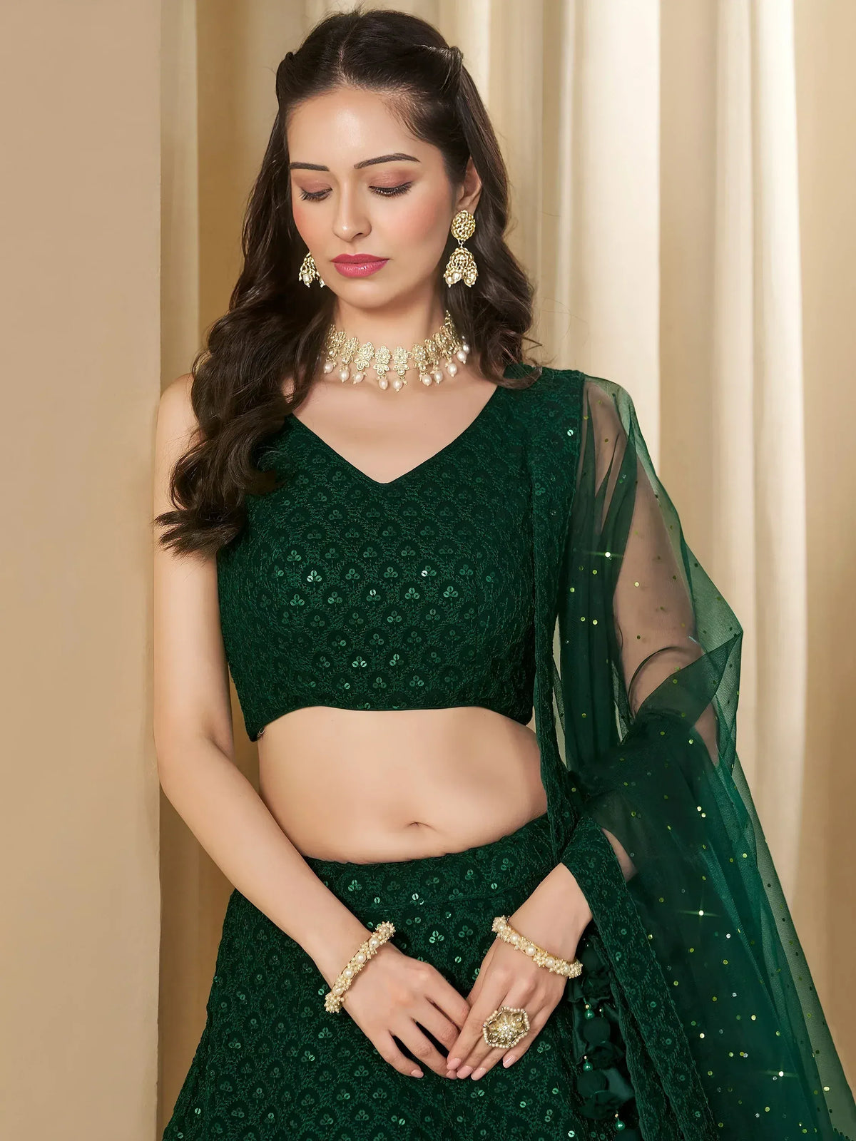 Emerald green sequined lehenga choli with sheer dupatta and gold jewelry