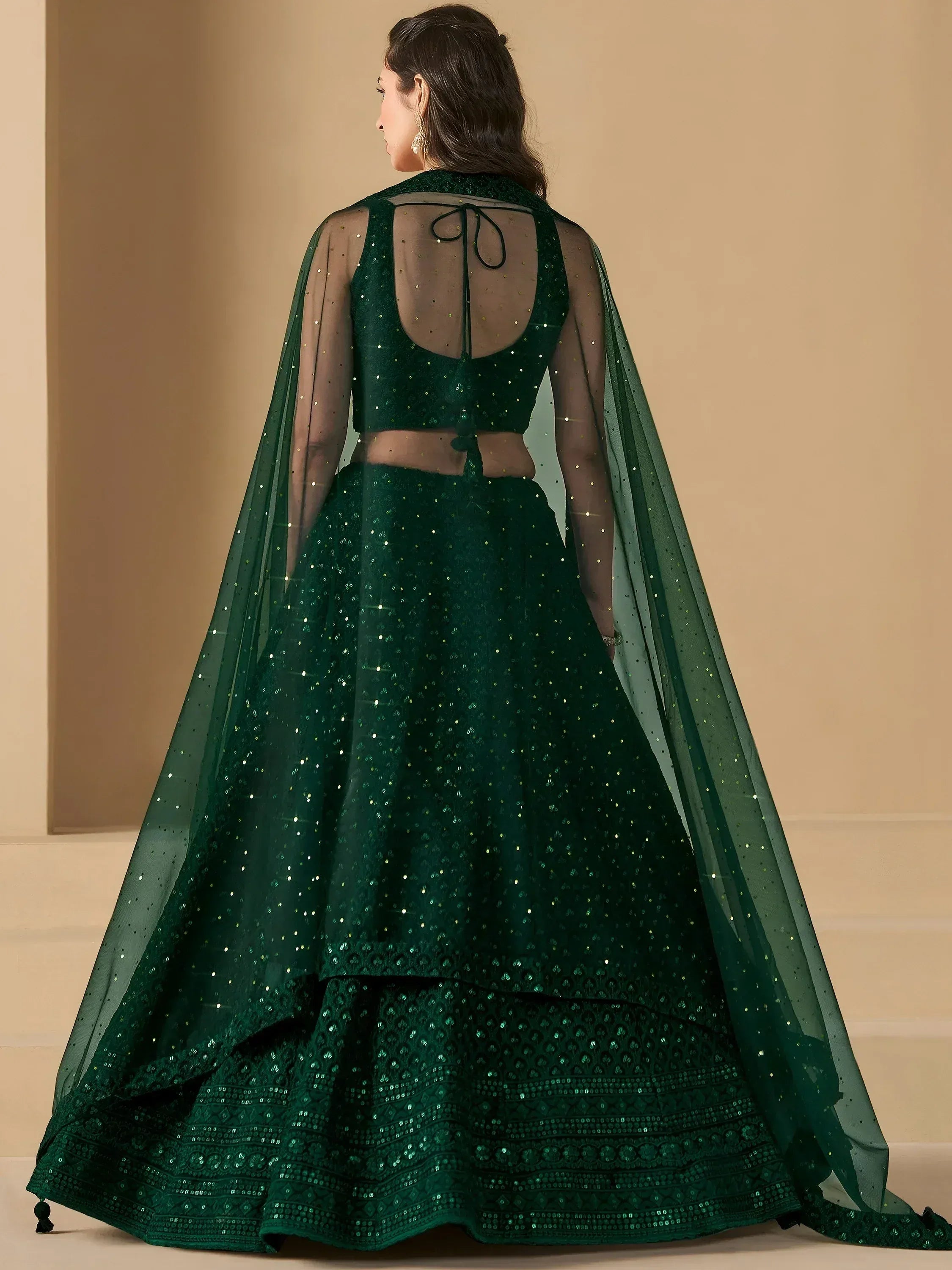 Emerald green sequined lehenga choli with sheer cape, perfect for Indian ethnic wear events.