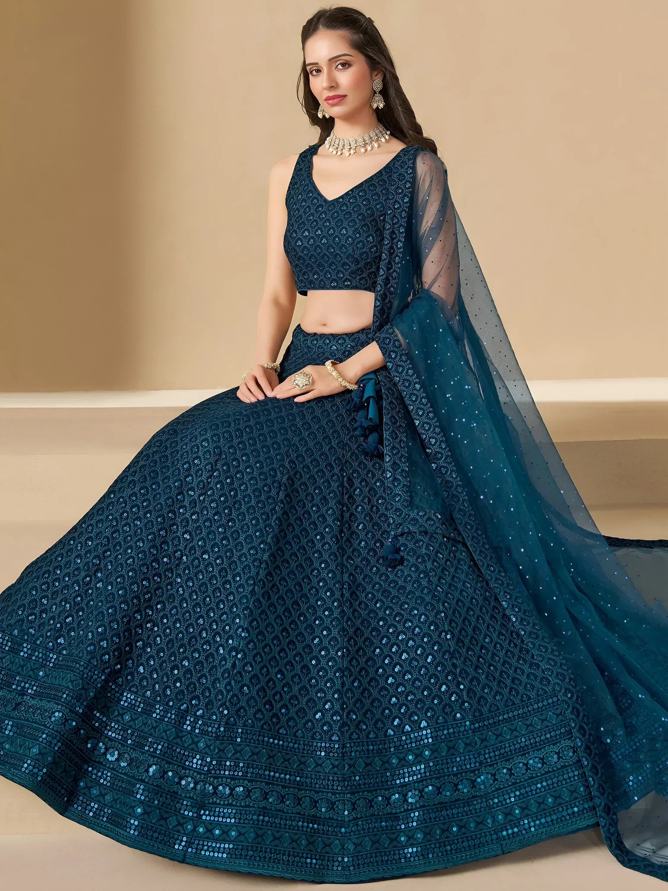 Elegant teal lehenga choli with intricate embroidery and sequin detailing for festive occasions