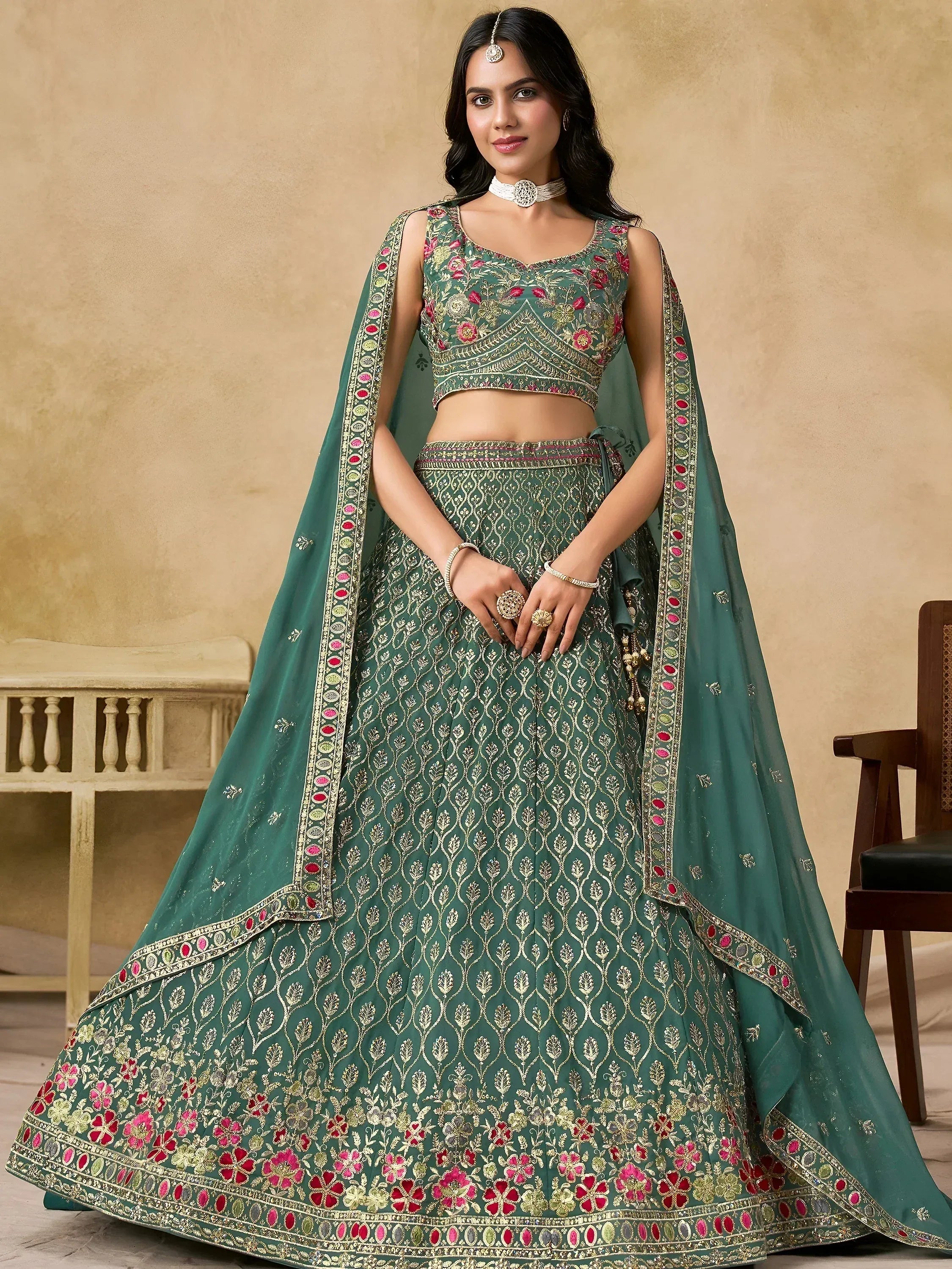 Emerald green designer lehenga choli with floral embroidery and gold detailing, perfect for Indian weddings.
