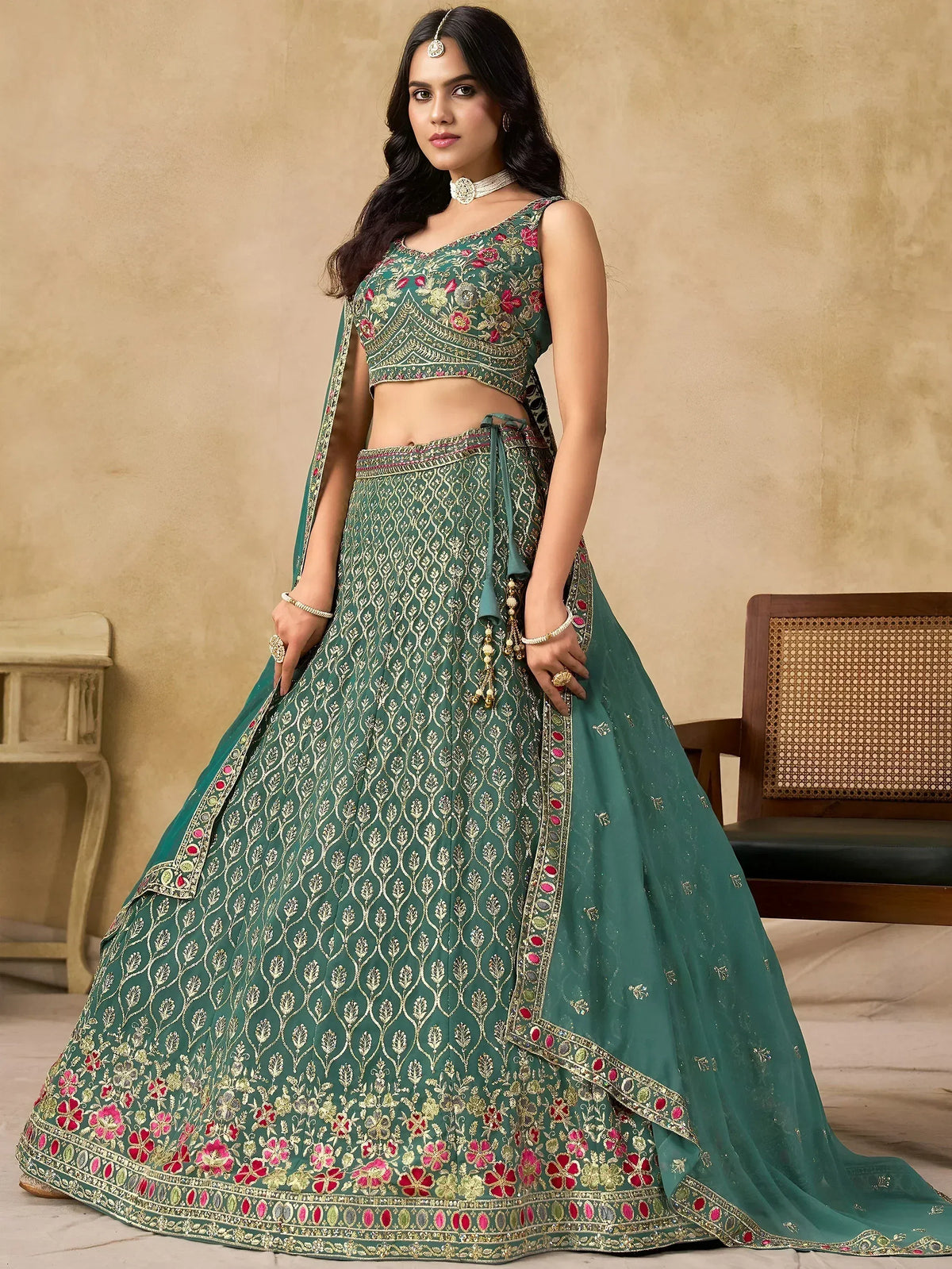 Emerald green designer lehenga choli with floral embroidery and gold detailing, perfect for Indian weddings.