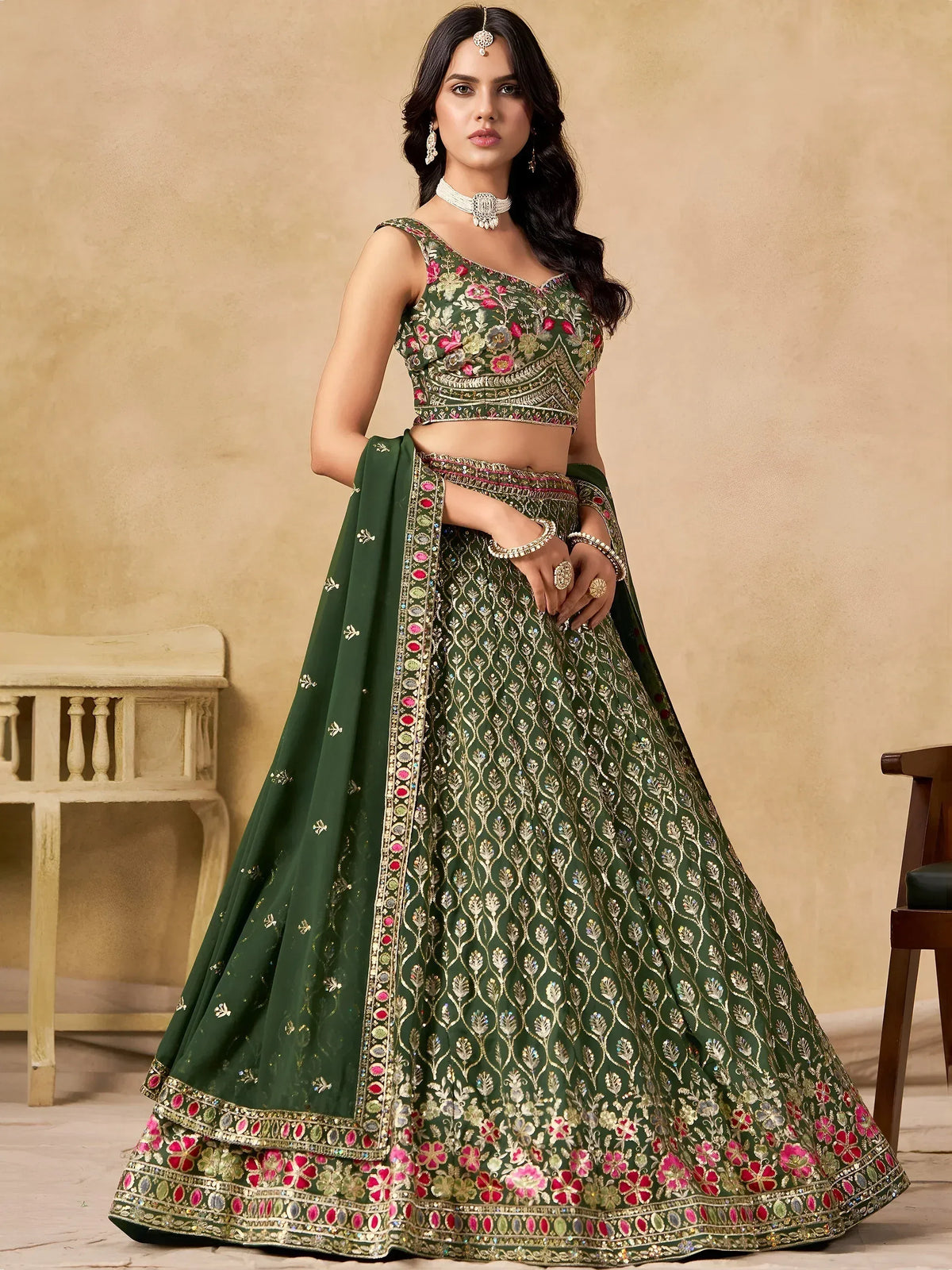 Emerald green designer lehenga choli with floral embroidery and gold detailing, perfect for weddings and festive occasions.