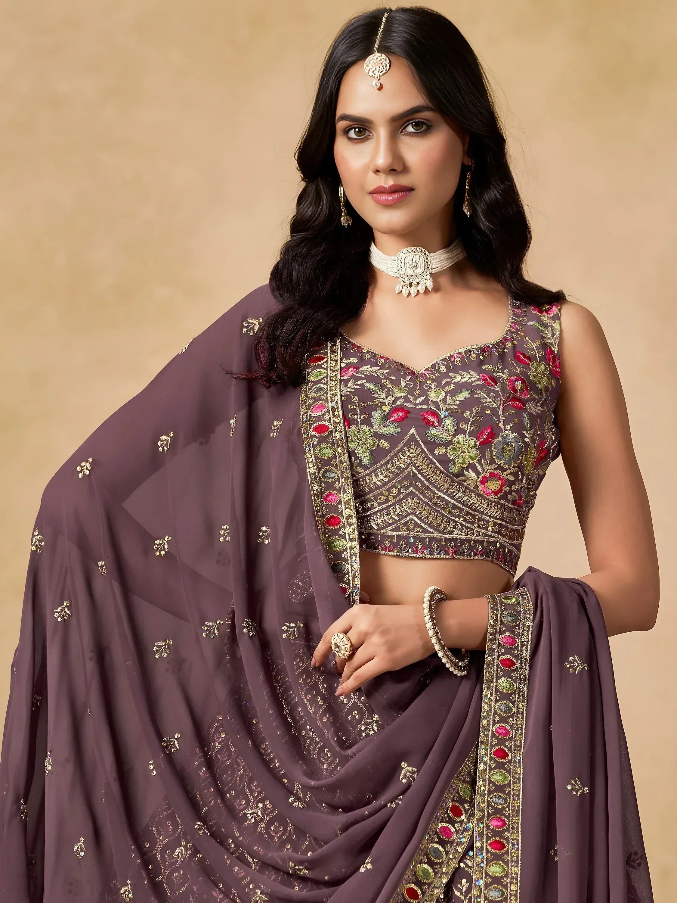 Elegant purple embroidered lehenga choli with floral motifs and gold detailing, perfect for Indian ethnic wear.