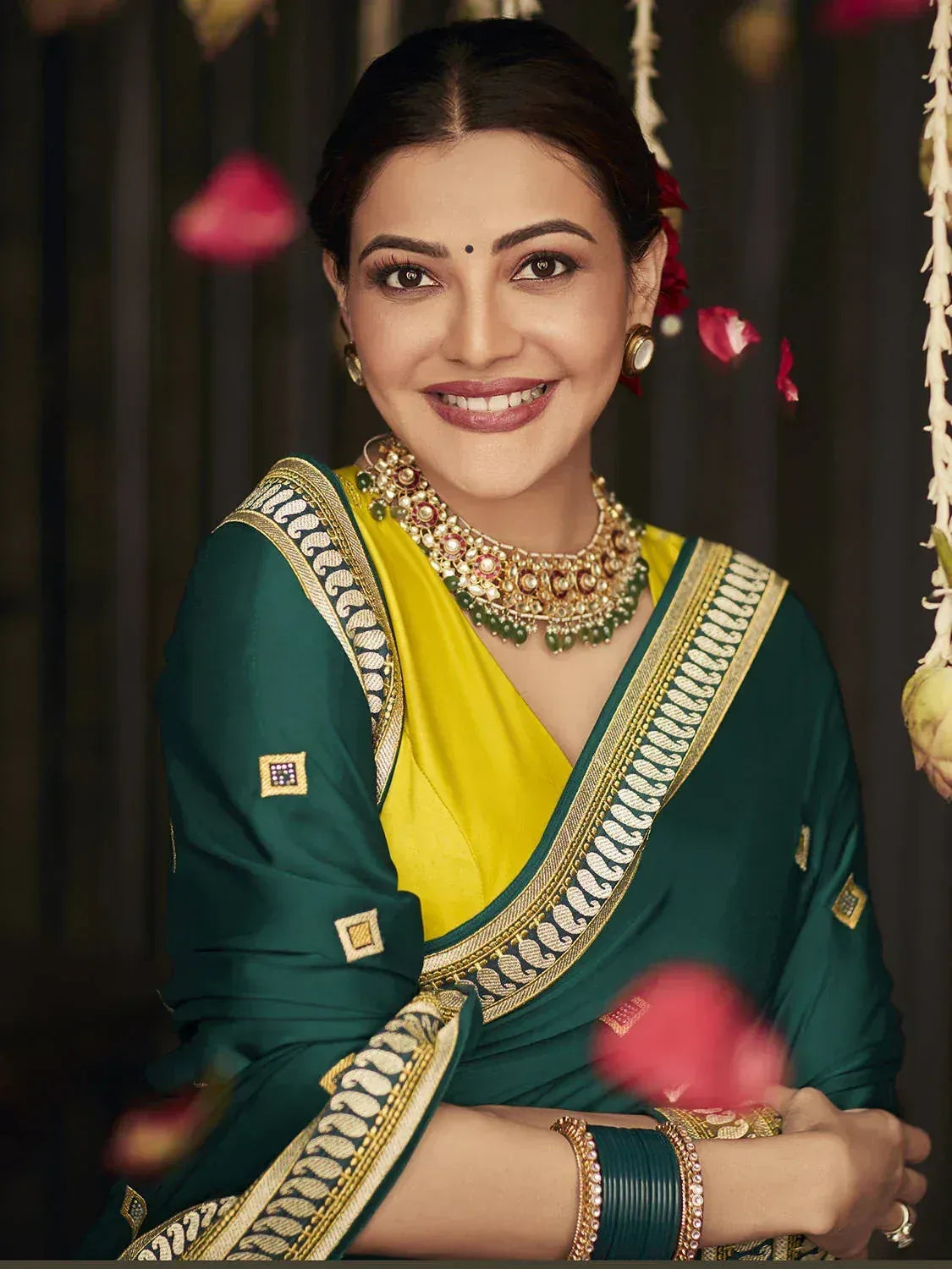 Woman in green and yellow designer saree with gold embroidery and traditional jewelry