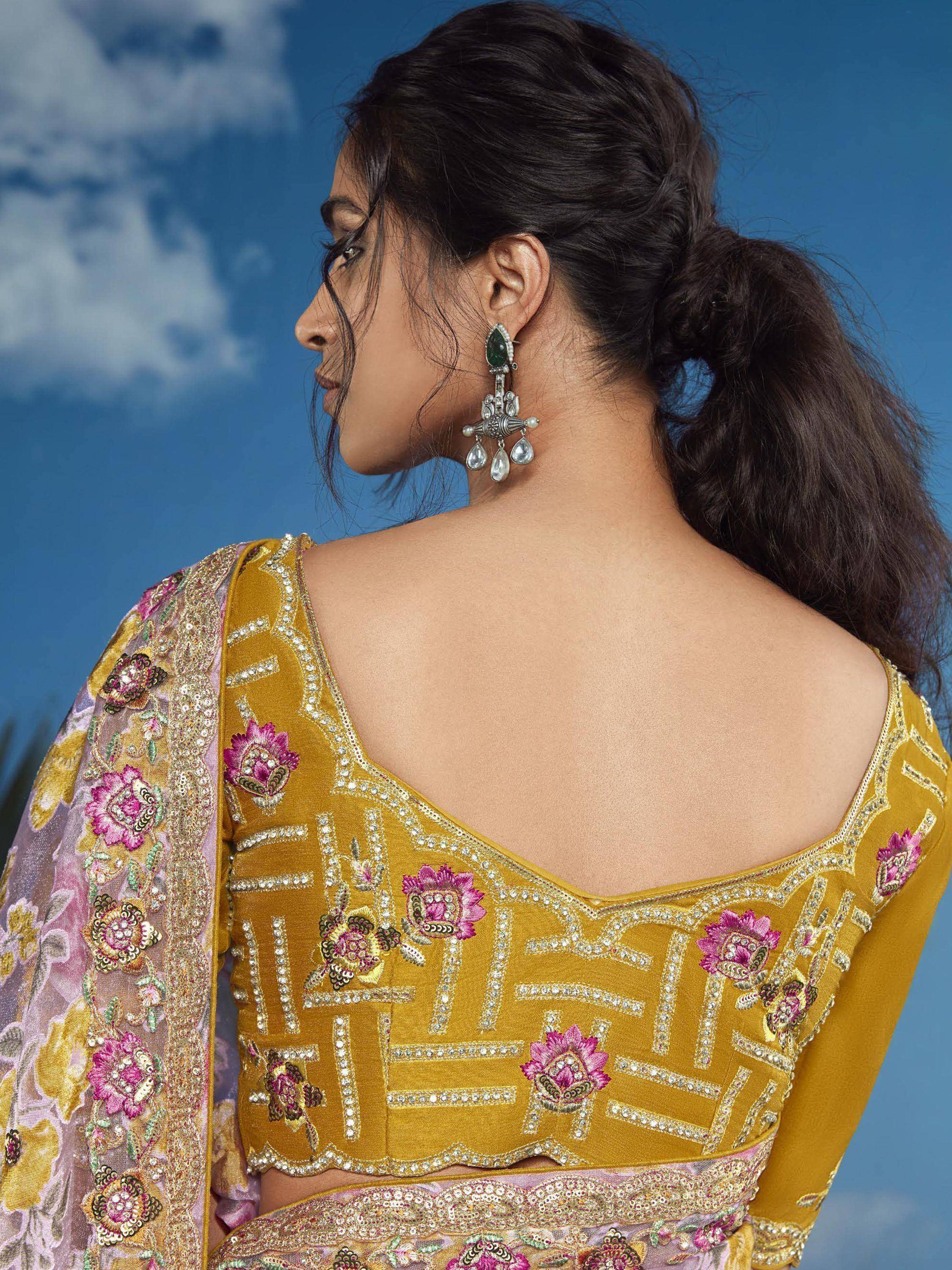 Yellow embroidered lehenga choli with pink floral motifs and silver jewelry, perfect for Indian ethnic wear.