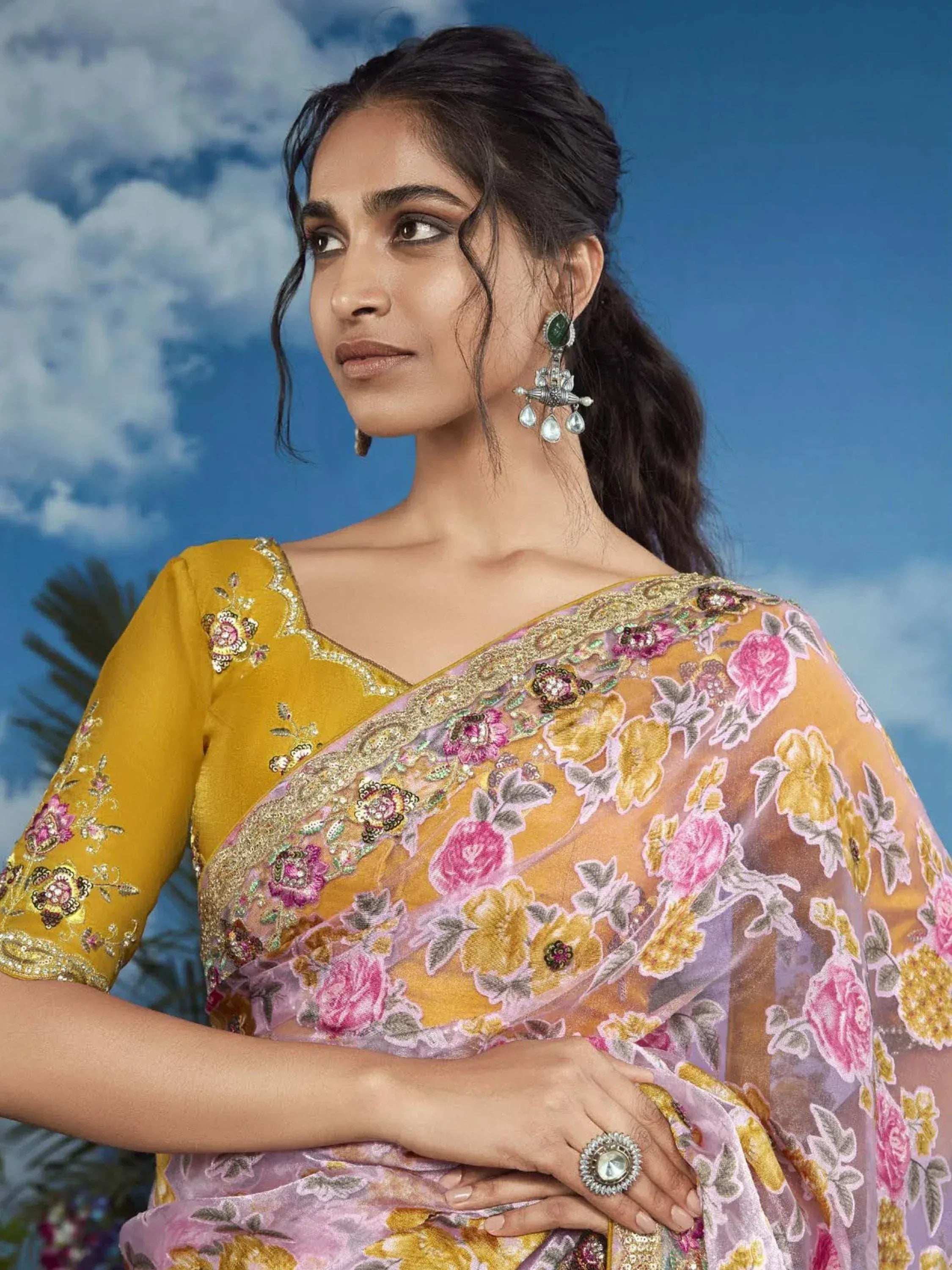 Woman in floral embroidered yellow and pink saree with gold detailing, traditional Indian ethnic wear