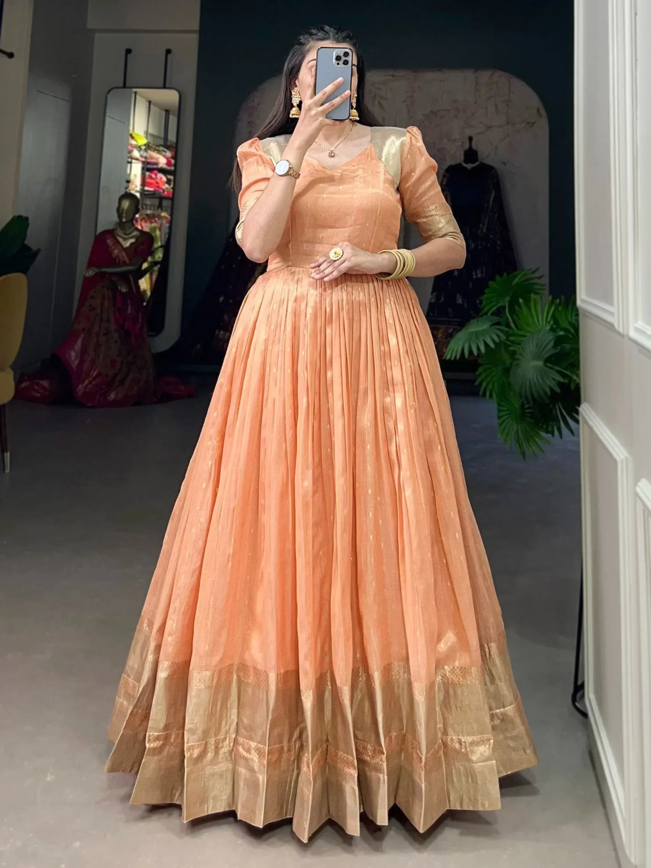 Peach ethnic gown with gold detailing, pleated skirt, puff sleeves, perfect for Indian occasions and weddings
