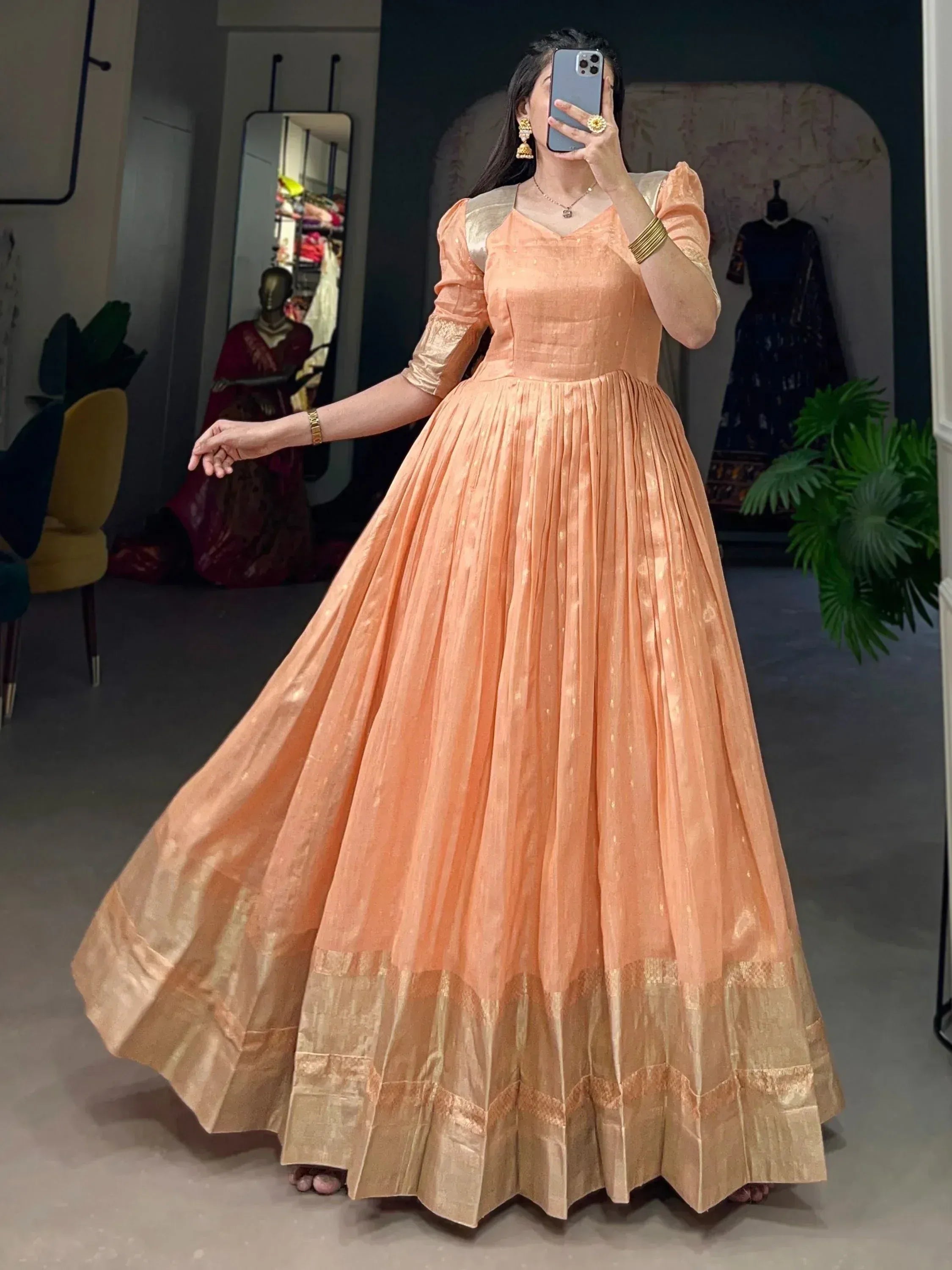 Peach ethnic gown with gold pleated skirt, puff sleeves, perfect for Indian weddings or festive occasions.