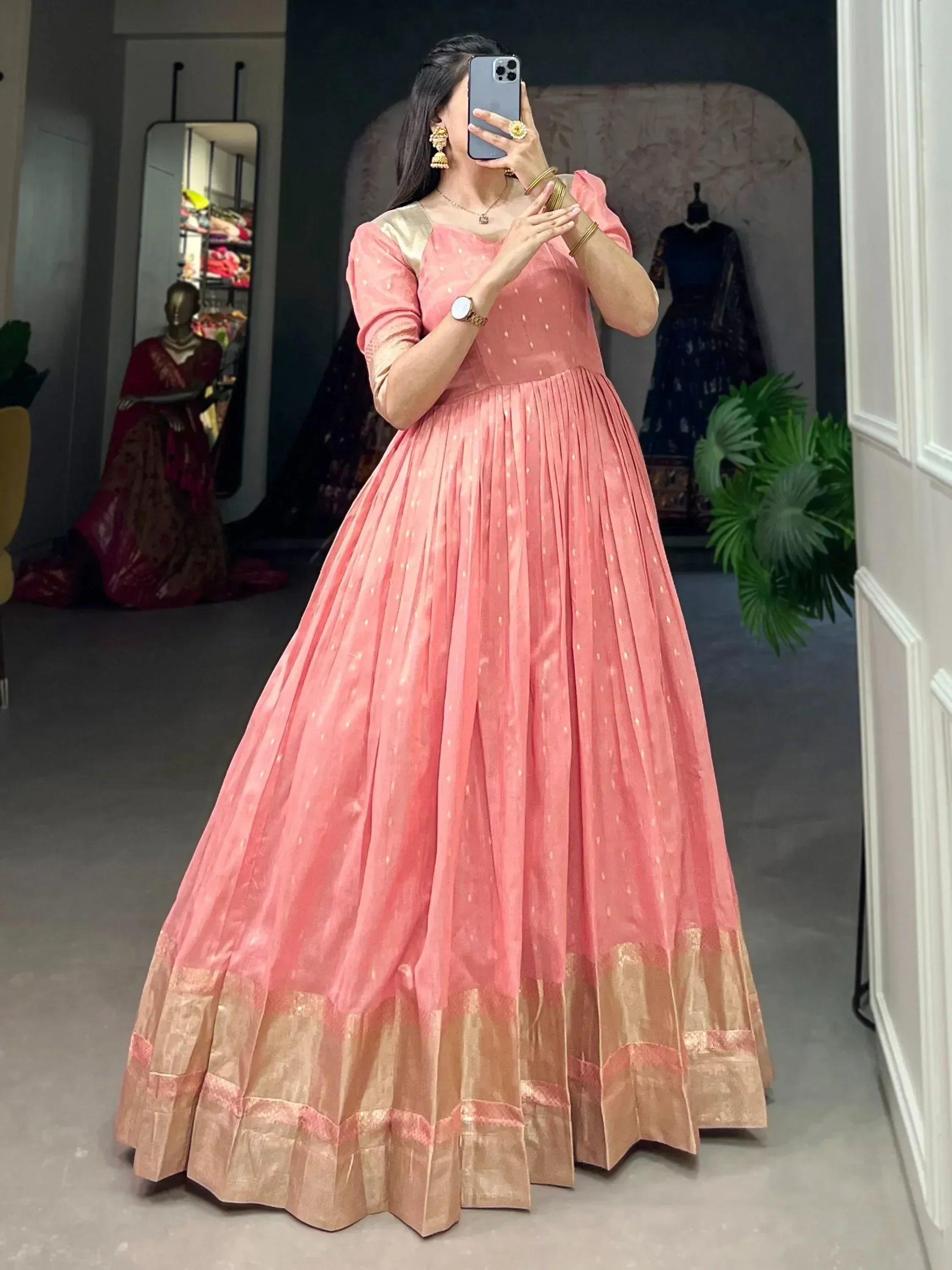 Pink ethnic gown with gold trim, pleated skirt, and puff sleeves for Indian occasions