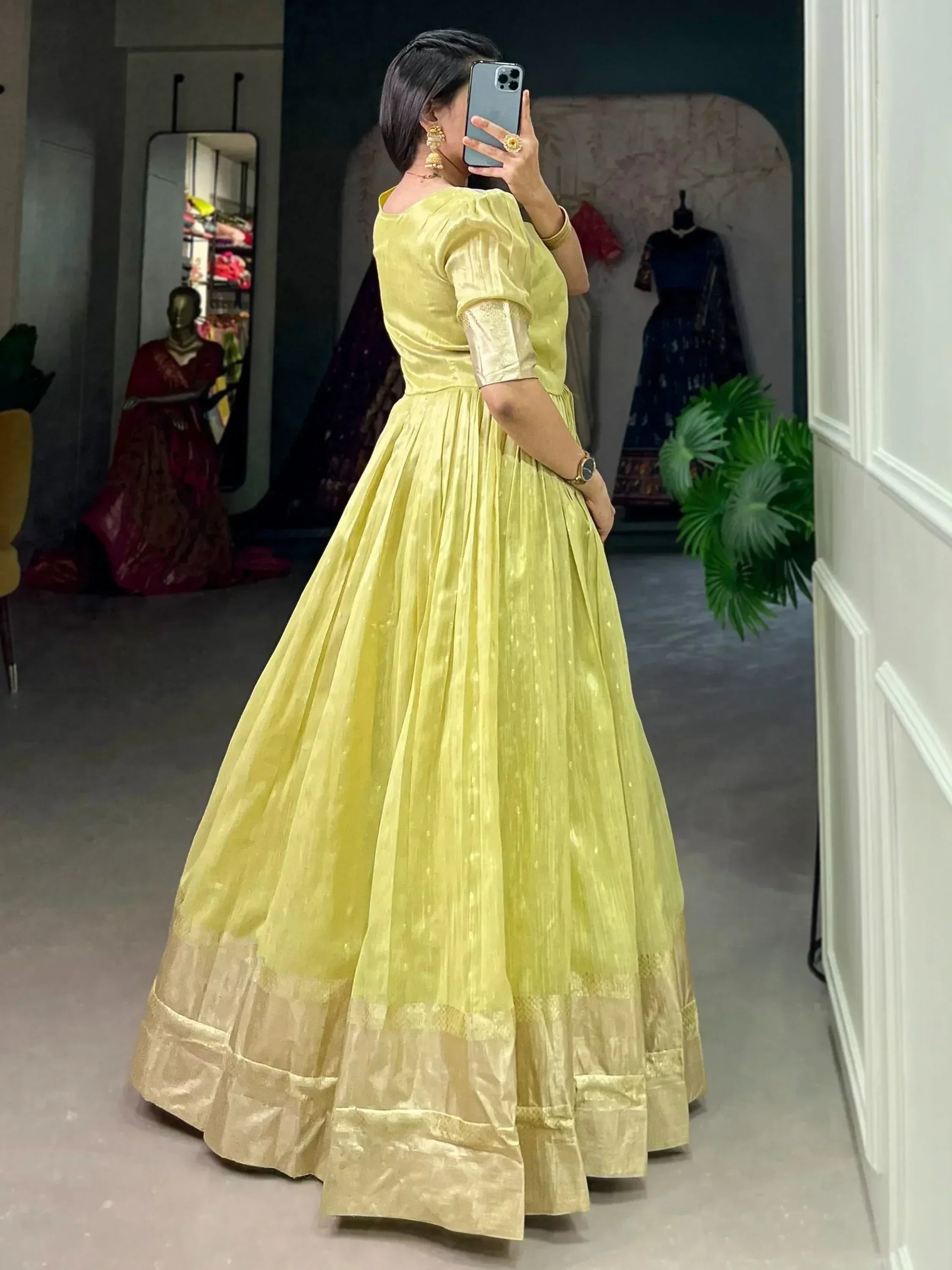 Yellow ethnic gown with gold border, puff sleeves, mirror selfie in boutique