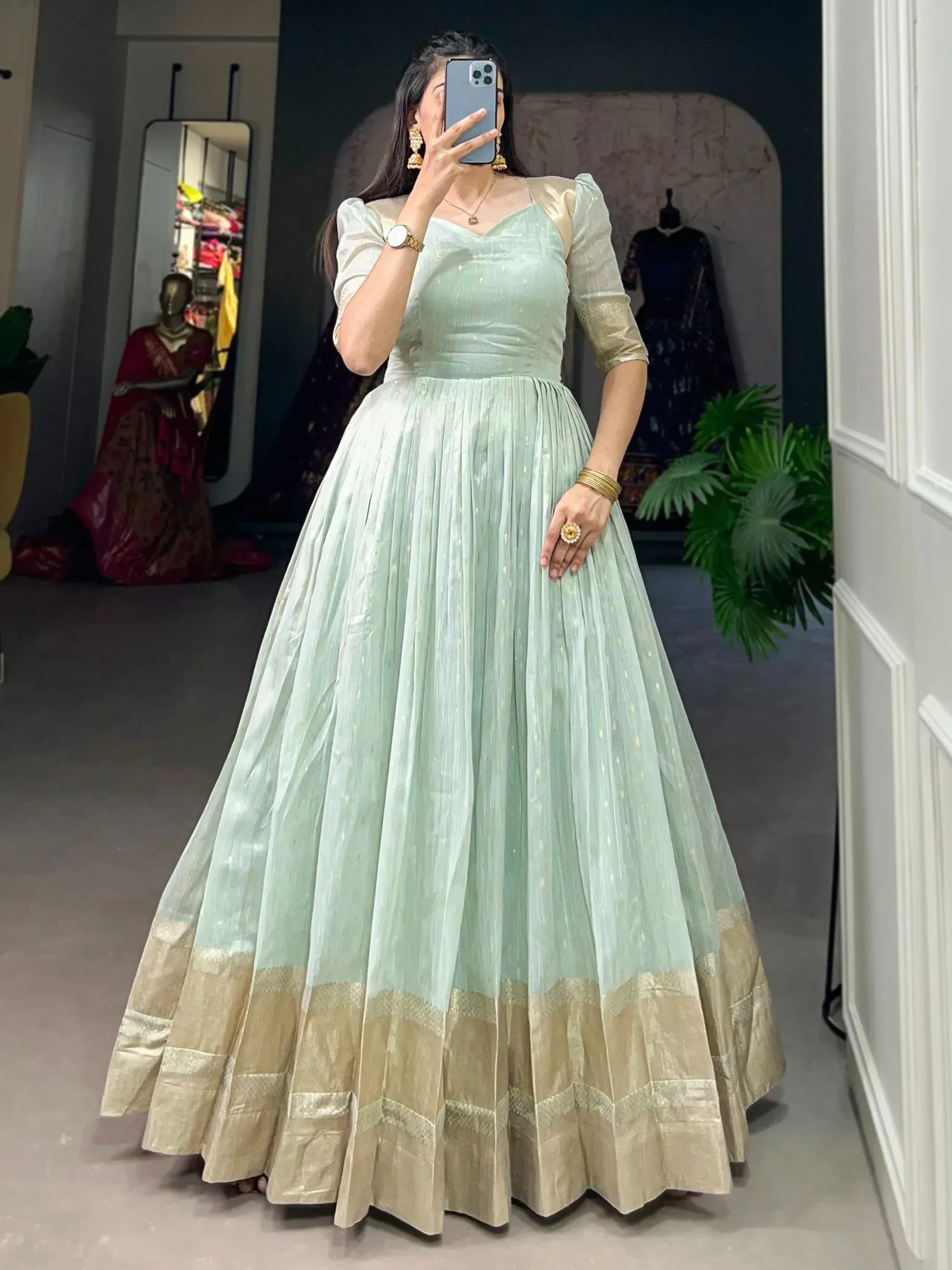 Mint green ethnic gown with gold trim, pleated skirt, and puff sleeves for Indian occasions