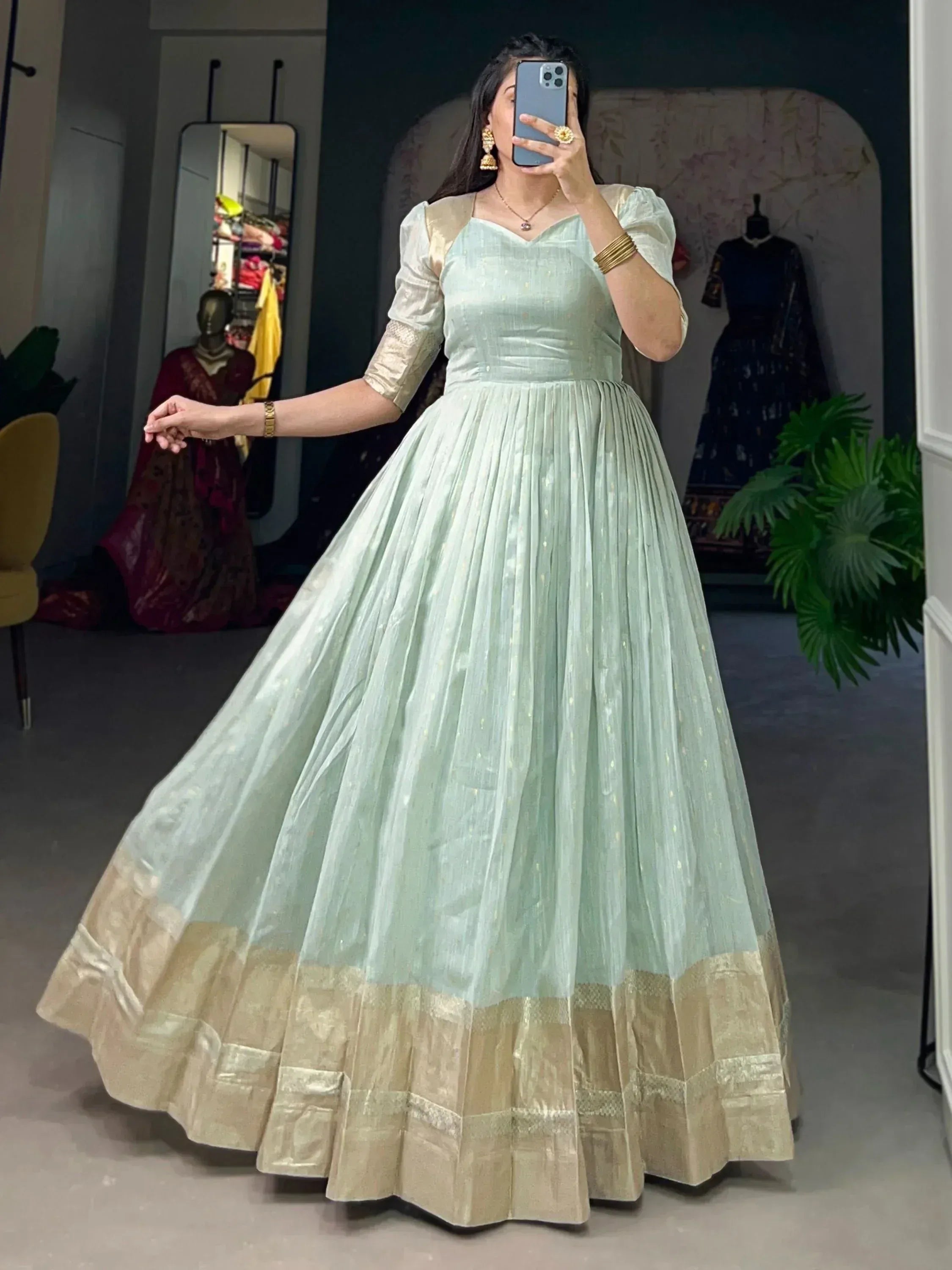 Mint green ethnic gown with gold border, puff sleeves, and pleated skirt for Indian occasions