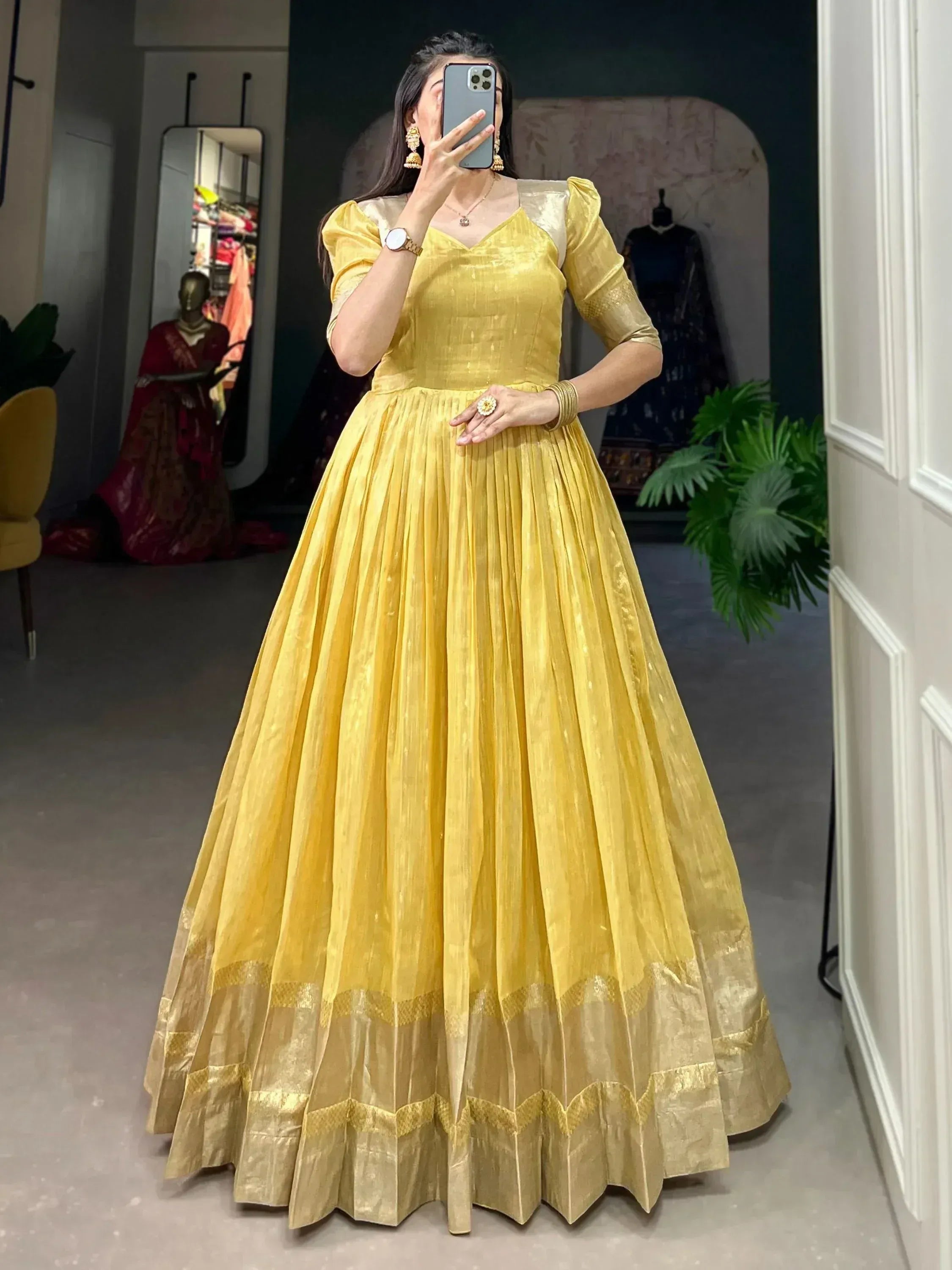 Yellow ethnic gown with pleated skirt and gold border, perfect for Indian occasions