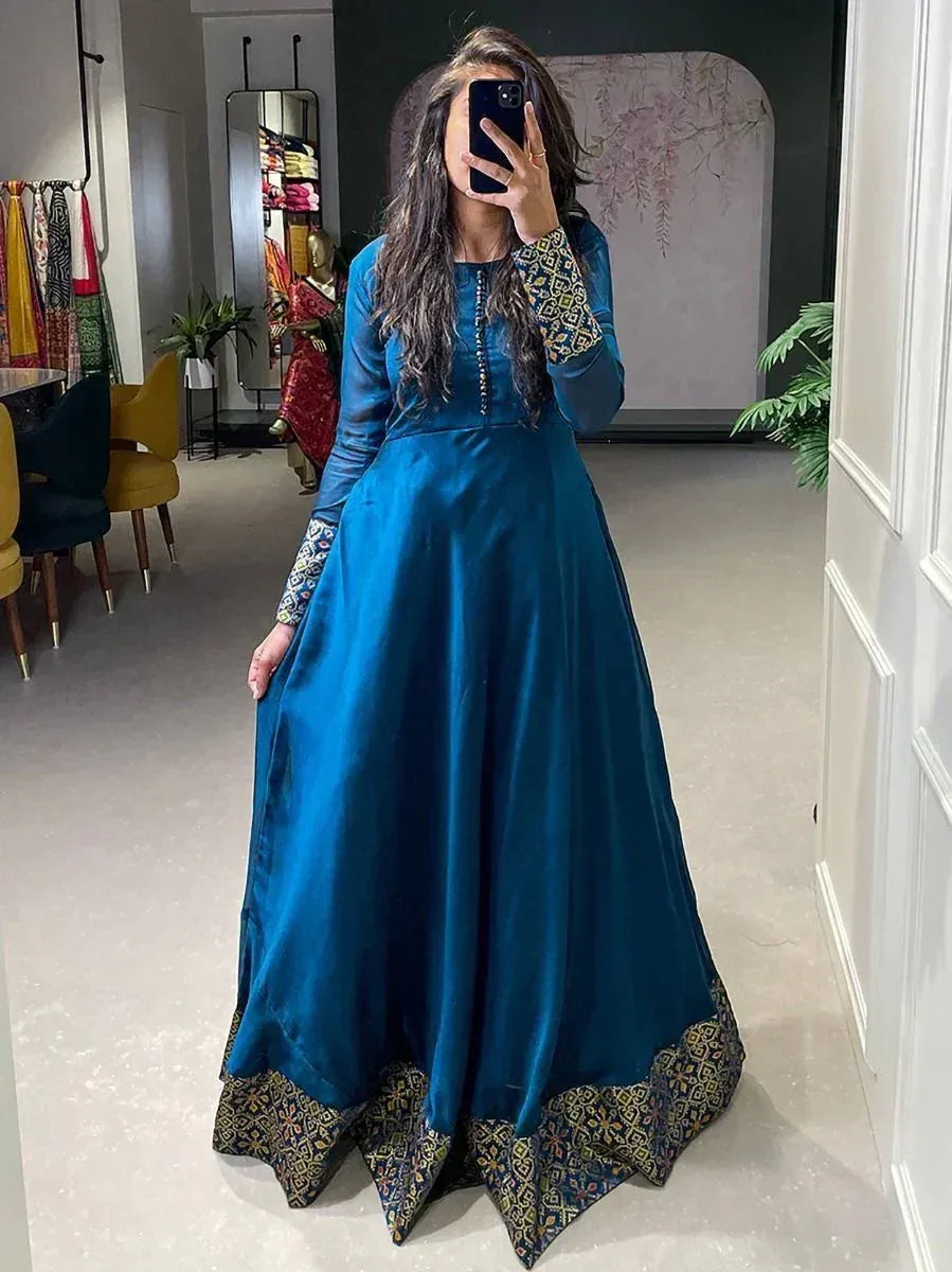 Teal blue ethnic gown with printed sleeves and hem, perfect for Indian occasions