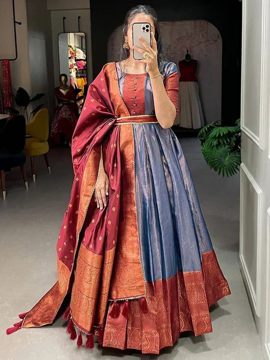 Woman in designer lehenga choli with red and blue silk, gold embroidery, and tassels, perfect for Indian ethnic wear.