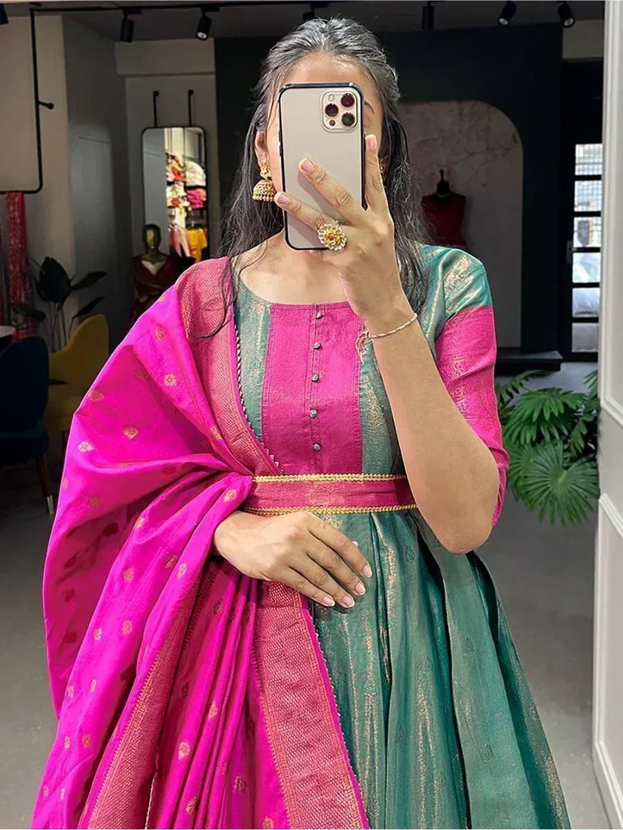 Woman in vibrant pink and green ethnic gown with gold detailing, perfect for festive occasions