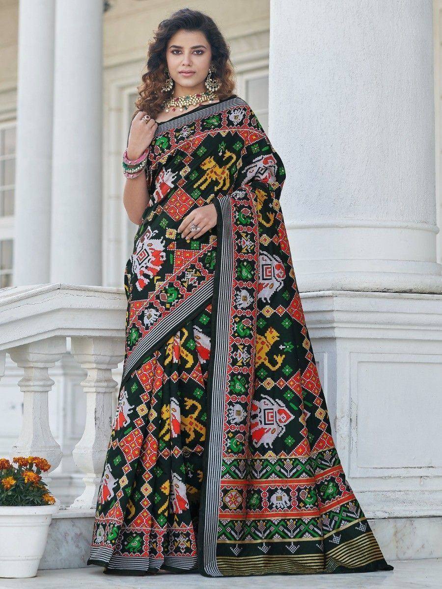 Woman in vibrant black printed saree with elephant motifs, traditional Indian ethnic wear