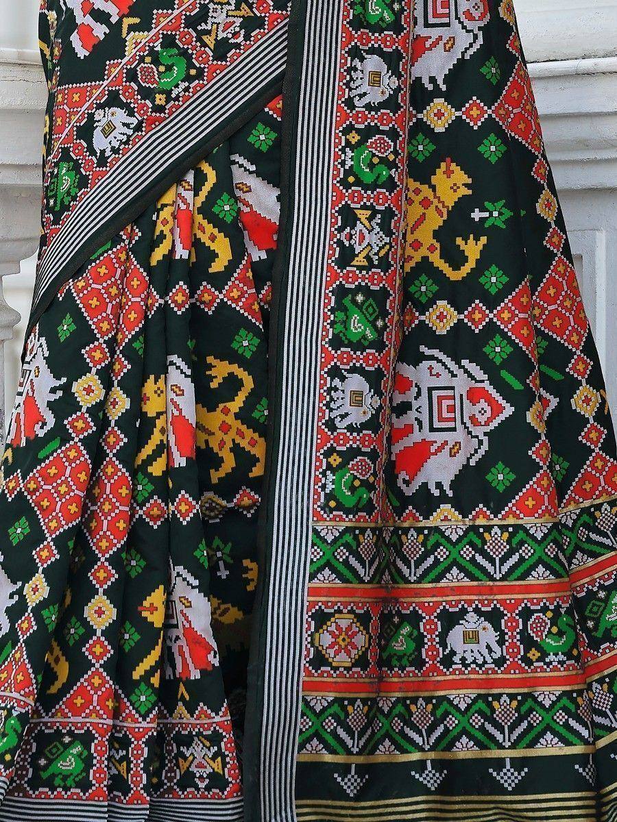 Black saree with vibrant red, green, yellow pixel-art animal and geometric prints, perfect for ethnic wear.