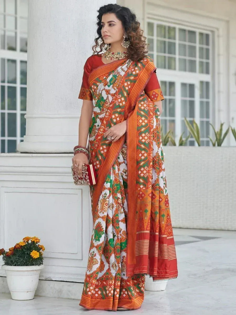Woman in vibrant orange and green printed saree with matching blouse, traditional Indian ethnic wear