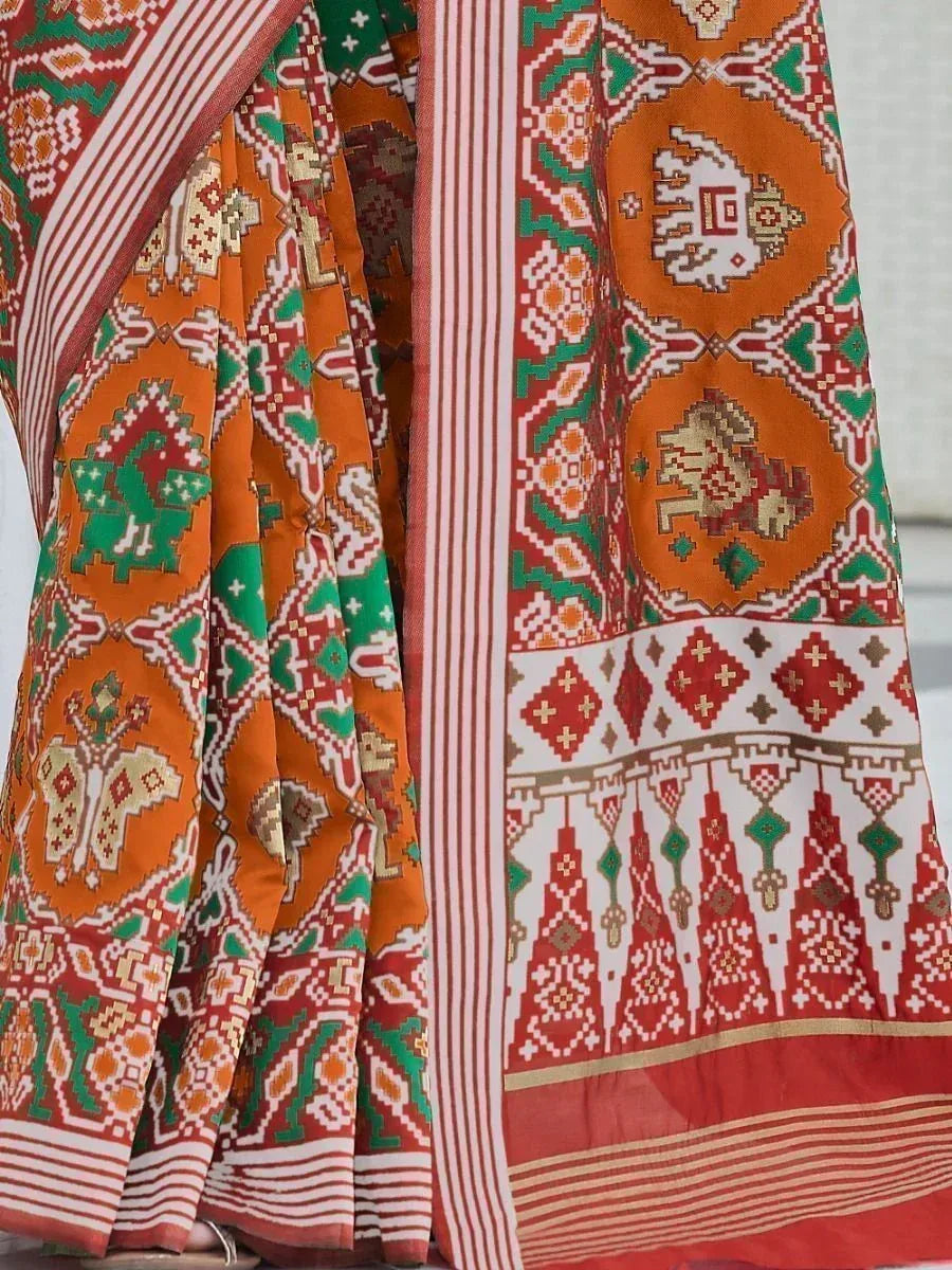 Vibrant orange and green ethnic saree with intricate geometric patterns and striped border